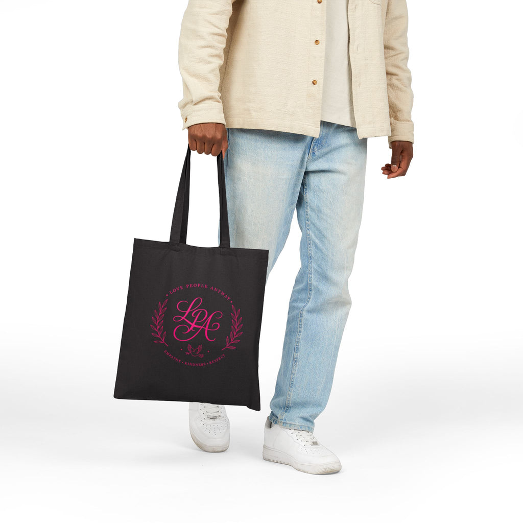 Pink monogram cotton canvas tote bag featuring the message “Love People Anyway,” laurel branches, a dove carrying an olive branch, and the words empathy, kindness, and respect in an elegant boutique design.