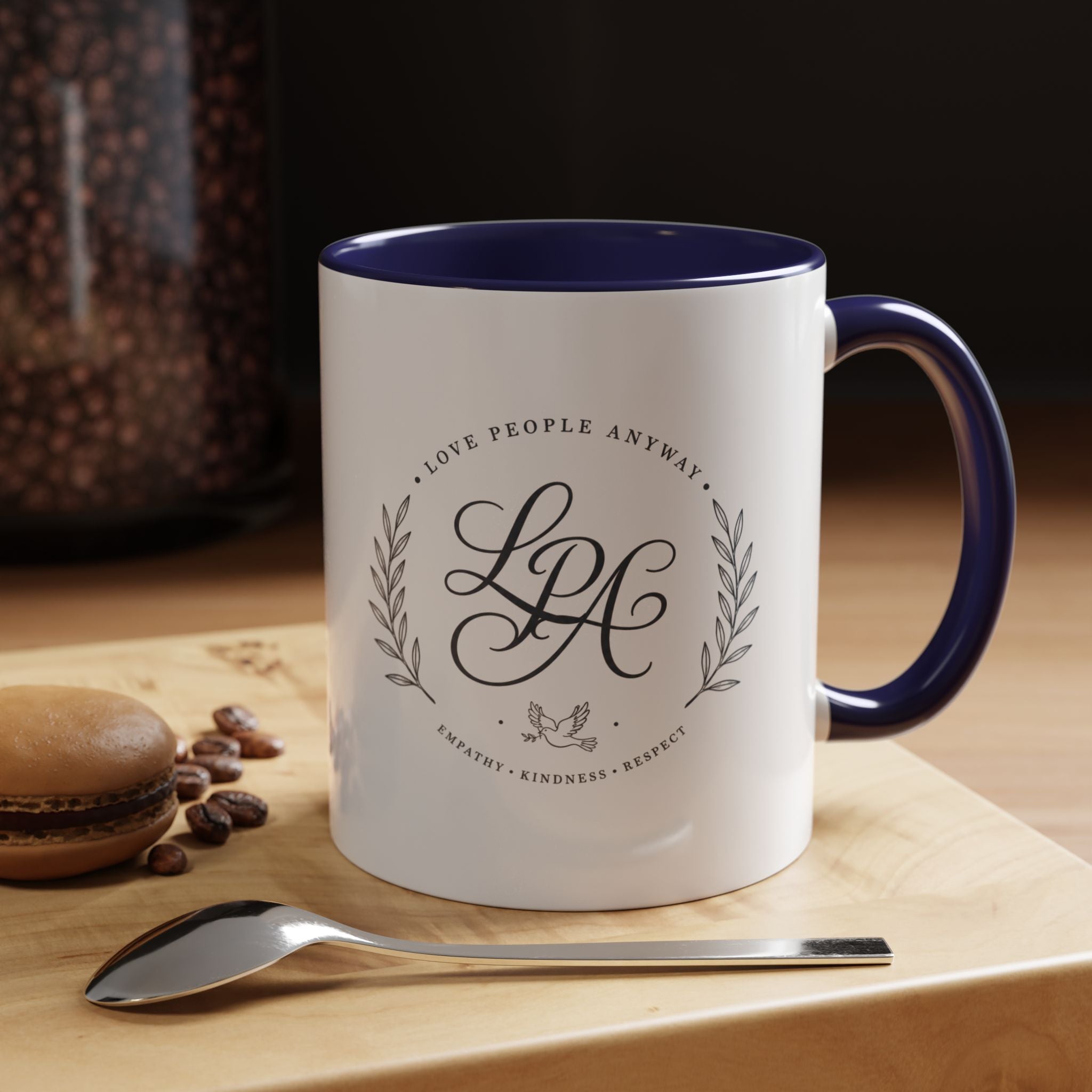 Personalized ceramic accent coffee mug featuring a custom monogram crest and the inspirational message “Love People Anyway” with colorful handle and interior accents.