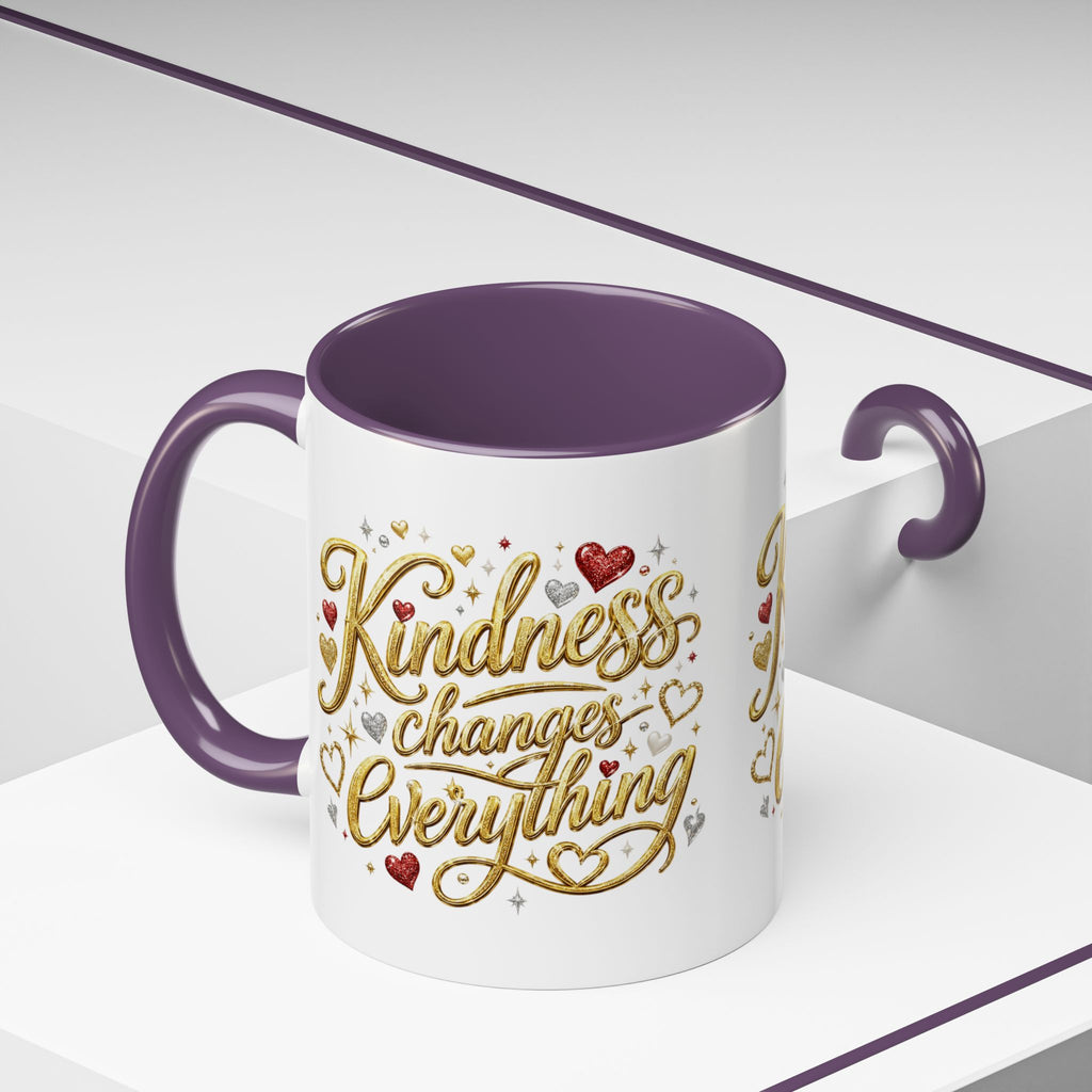 Inspirational ceramic coffee mug featuring the hand-lettered message “Kindness Changes Everything” with gold flourishes, hearts, and colorful accent handle and interior.