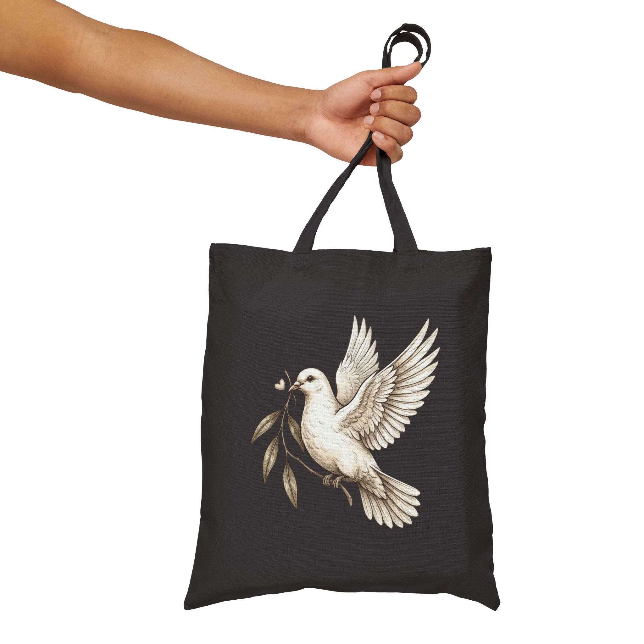 Cotton canvas tote bag featuring a vintage-style dove carrying an olive branch, symbolizing peace, hope, faith, and renewal in a rustic black-and-cream design.