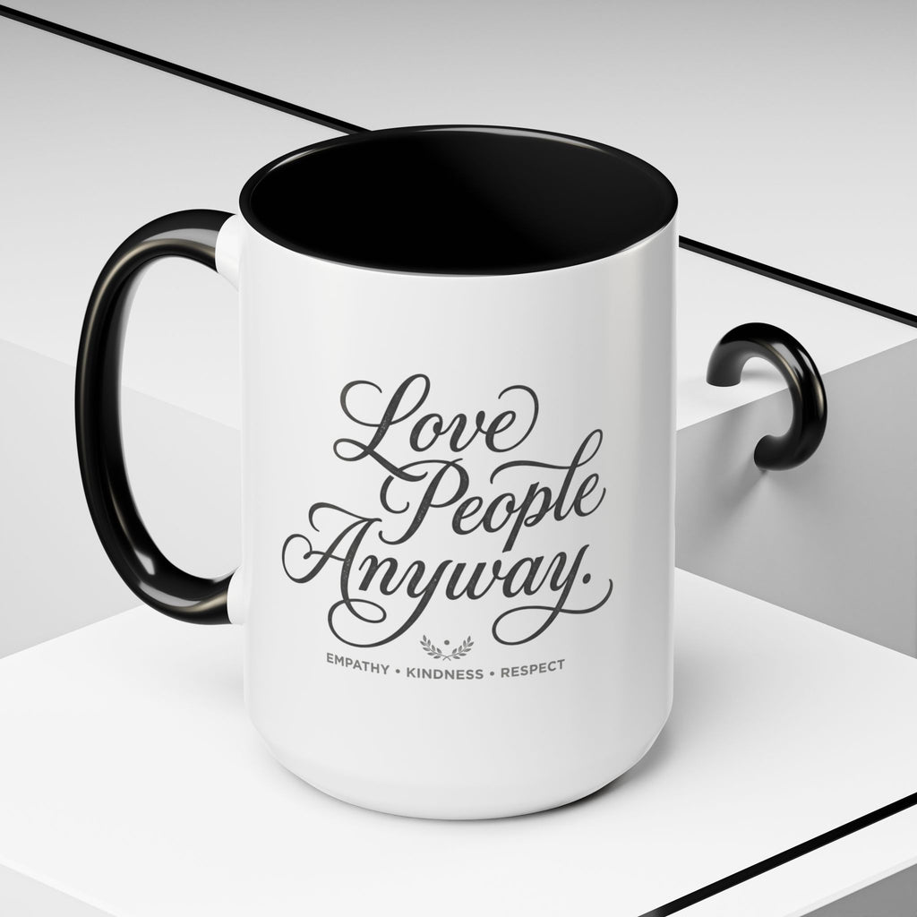 Inspirational ceramic accent coffee mug featuring hand-lettered “Love People Anyway” typography with empathy, kindness, and respect message on a glossy white mug with colorful handle and interior.