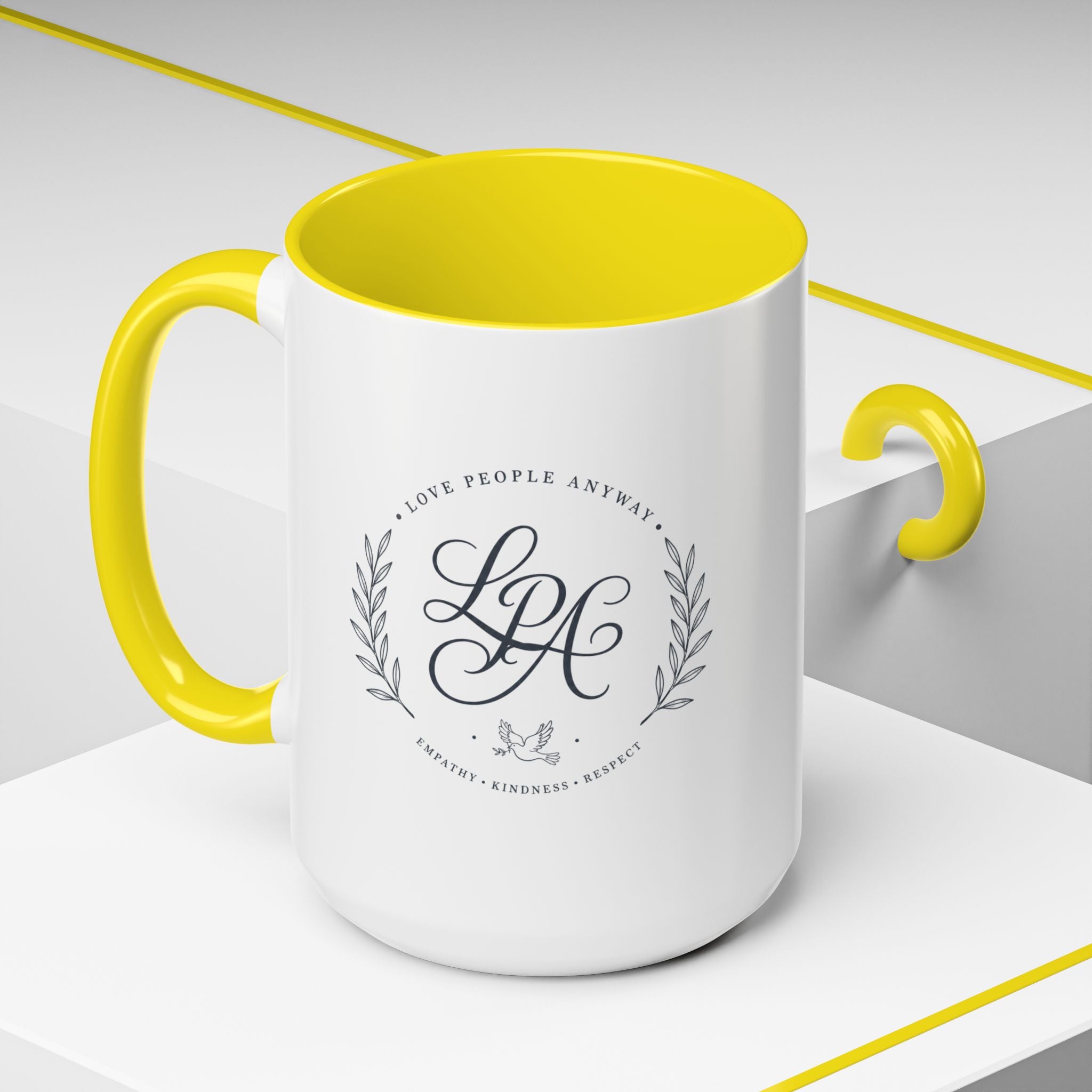 Personalized ceramic accent coffee mug featuring a custom monogram crest and the inspirational message “Love People Anyway” with colorful handle and interior accents.