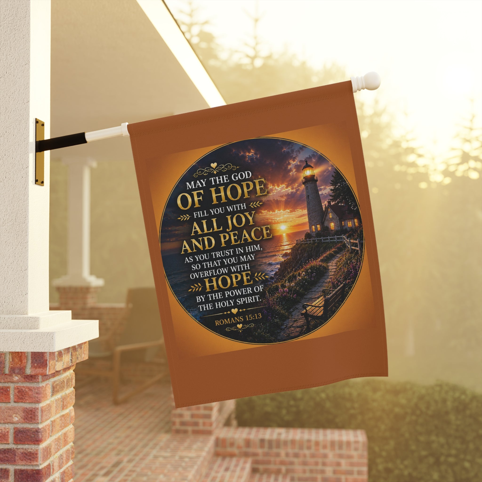 Inspirational Christian garden flag featuring a glowing lighthouse sunset with Romans 15:13 scripture artwork in warm coastal-inspired tones.