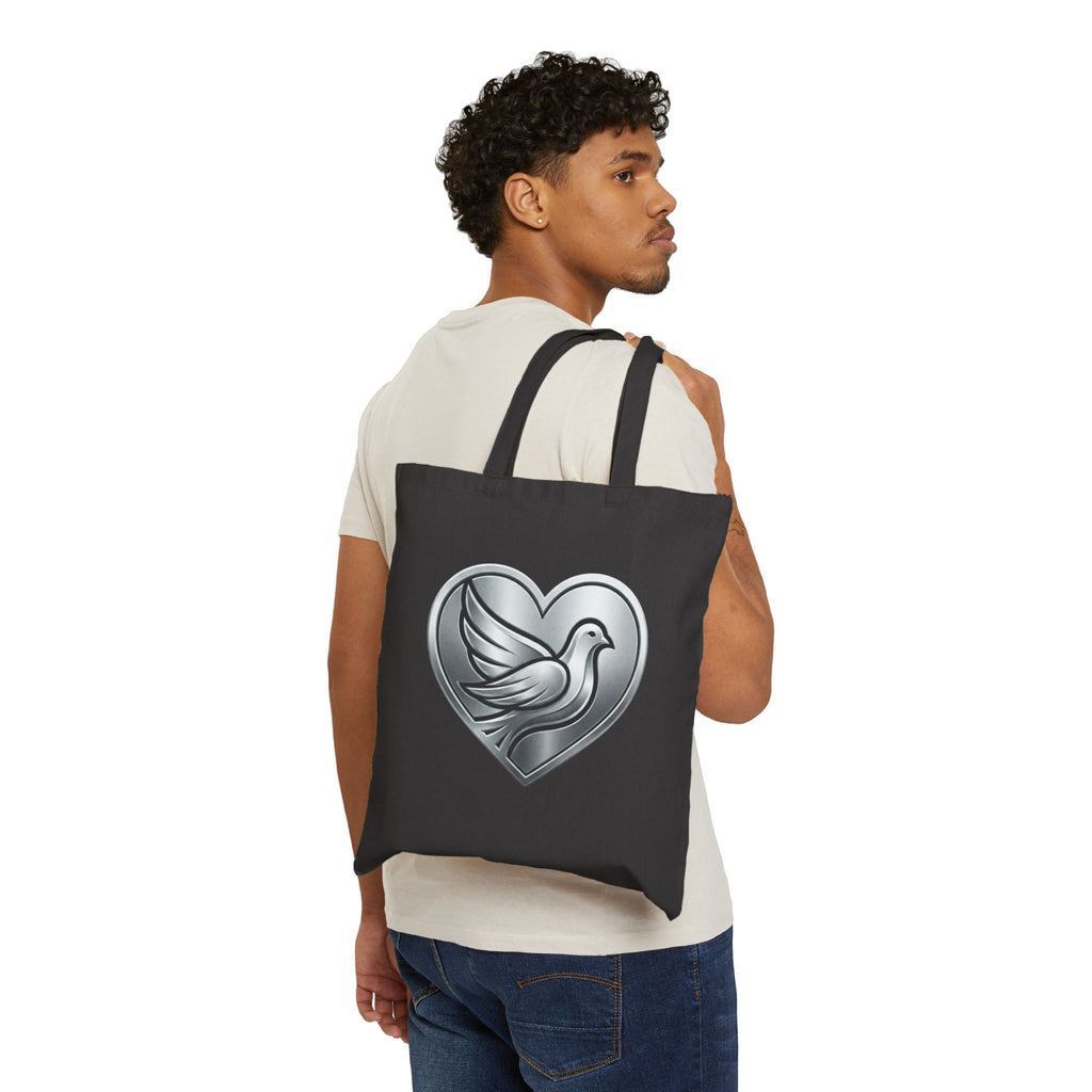 Cotton canvas tote bag featuring a silver dove inside a heart design, symbolizing peace, love, faith, hope, and encouragement in an elegant minimalist style.