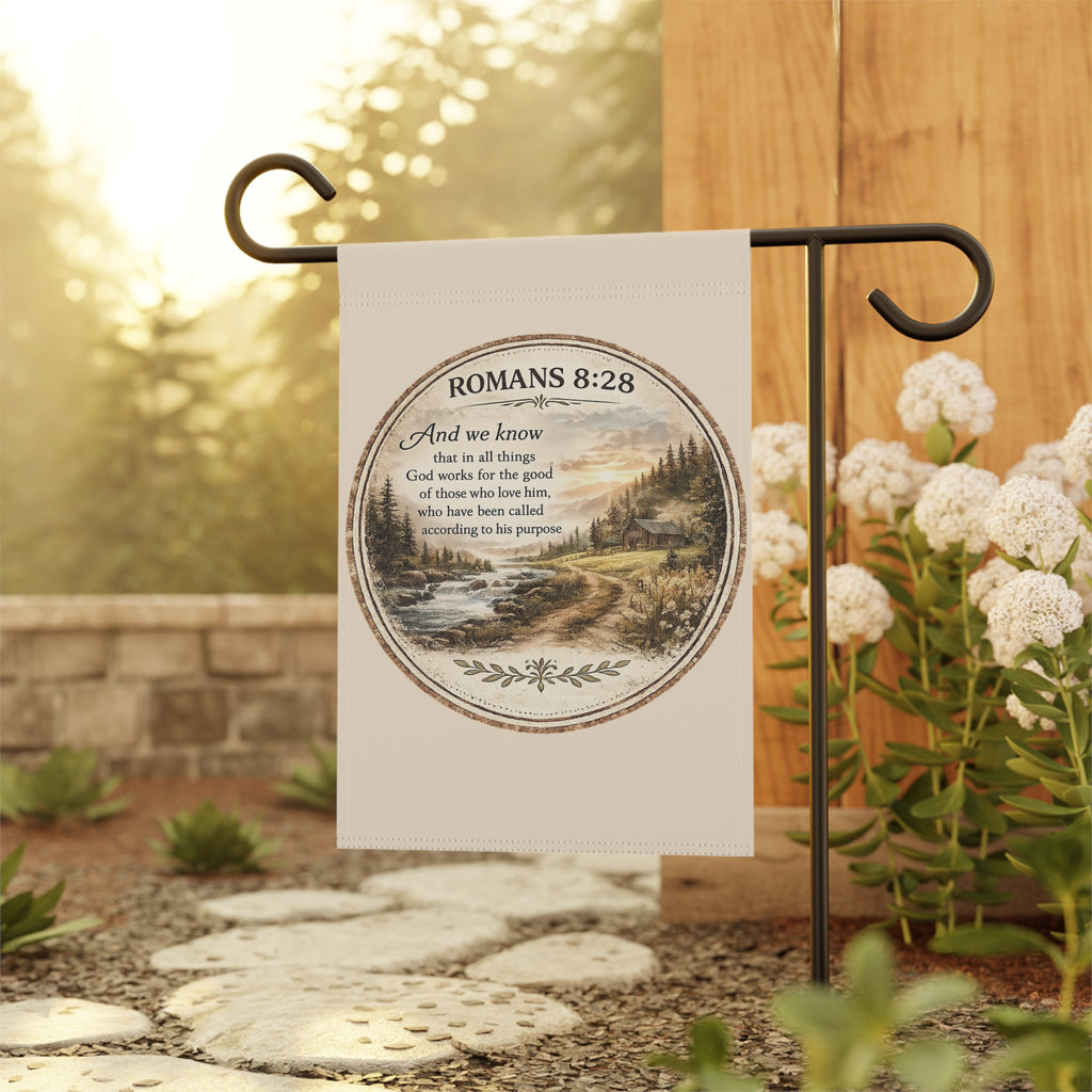 Christian garden flag featuring Romans 8:28 above a rustic river landscape with pine-covered hills, sunrise scenery, and farmhouse-inspired outdoor décor styling.