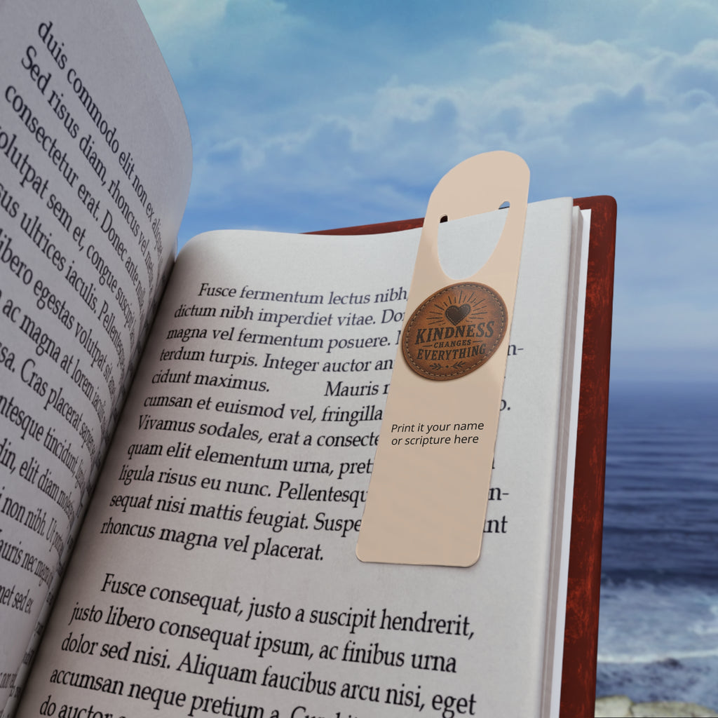 Personalized aluminum bookmark featuring a leather token design and the phrase “Kindness Changes Everything,” with custom name option, brushed metal backing, and secure page-holding slot.