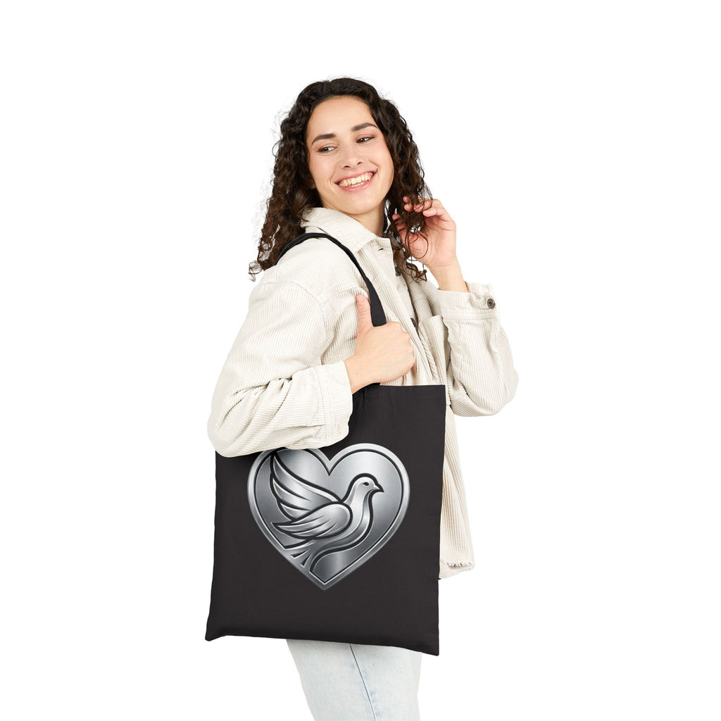 Cotton canvas tote bag featuring a silver dove inside a heart design, symbolizing peace, love, faith, hope, and encouragement in an elegant minimalist style.
