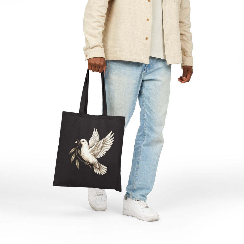 Cotton canvas tote bag featuring a vintage-style dove carrying an olive branch, symbolizing peace, hope, faith, and renewal in a rustic black-and-cream design.
