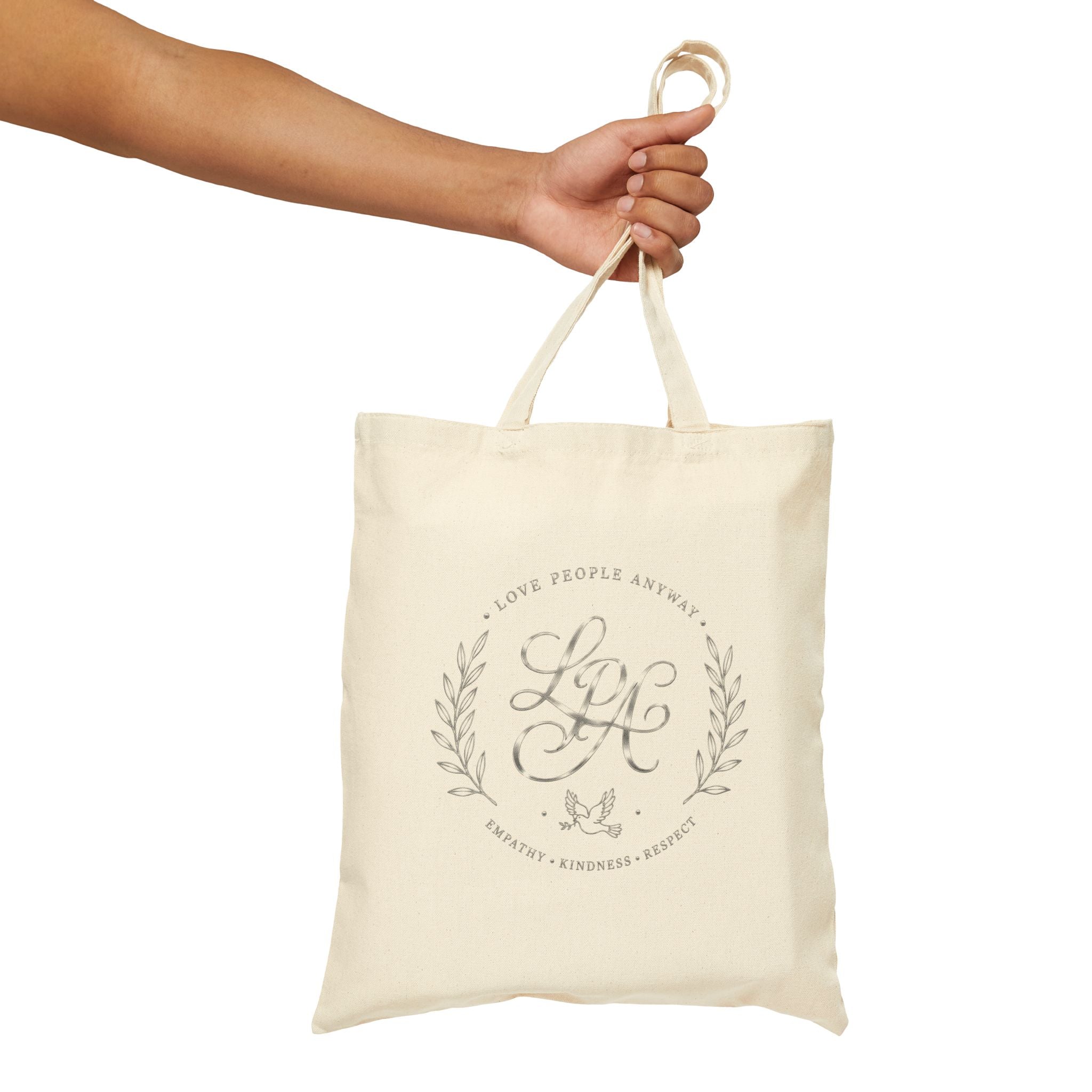 Elegant cotton canvas tote bag featuring a silver monogram crest, laurel branches, dove with olive branch, and the message “Love People Anyway” with empathy, kindness, and respect accents.