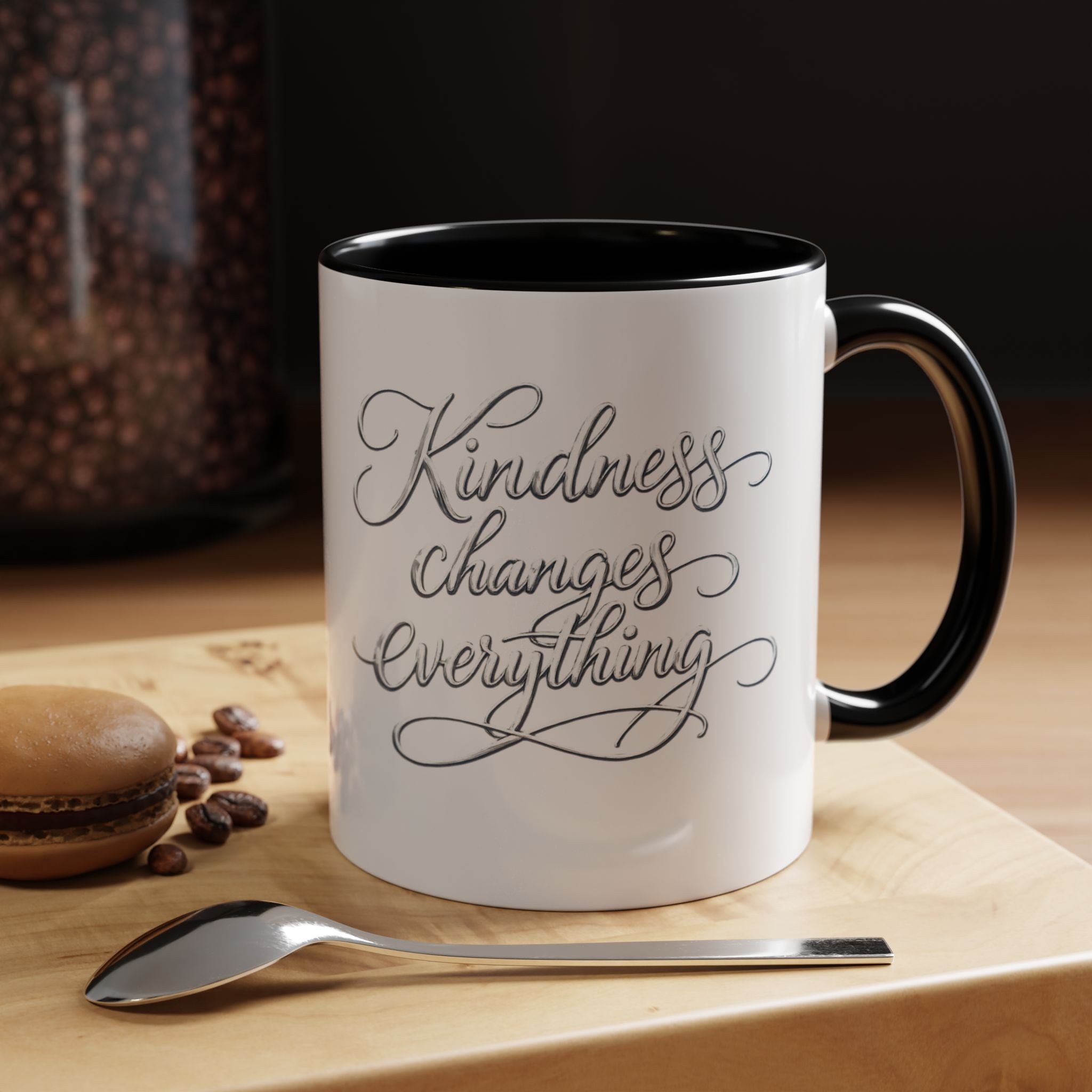 Inspirational ceramic accent coffee mug featuring elegant silver hand-lettered “Kindness Changes Everything” typography with colorful handle and interior accents.