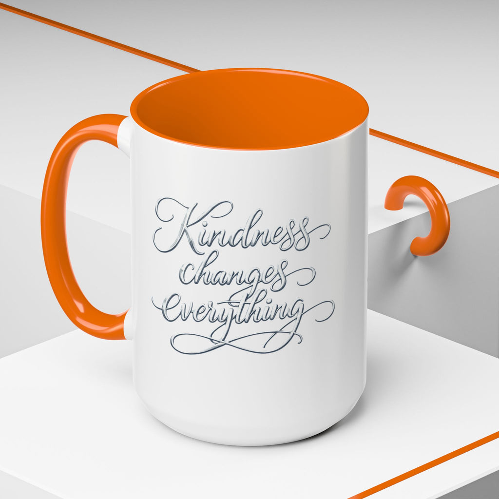 Inspirational ceramic accent coffee mug featuring elegant silver hand-lettered “Kindness Changes Everything” typography with colorful handle and interior accents.