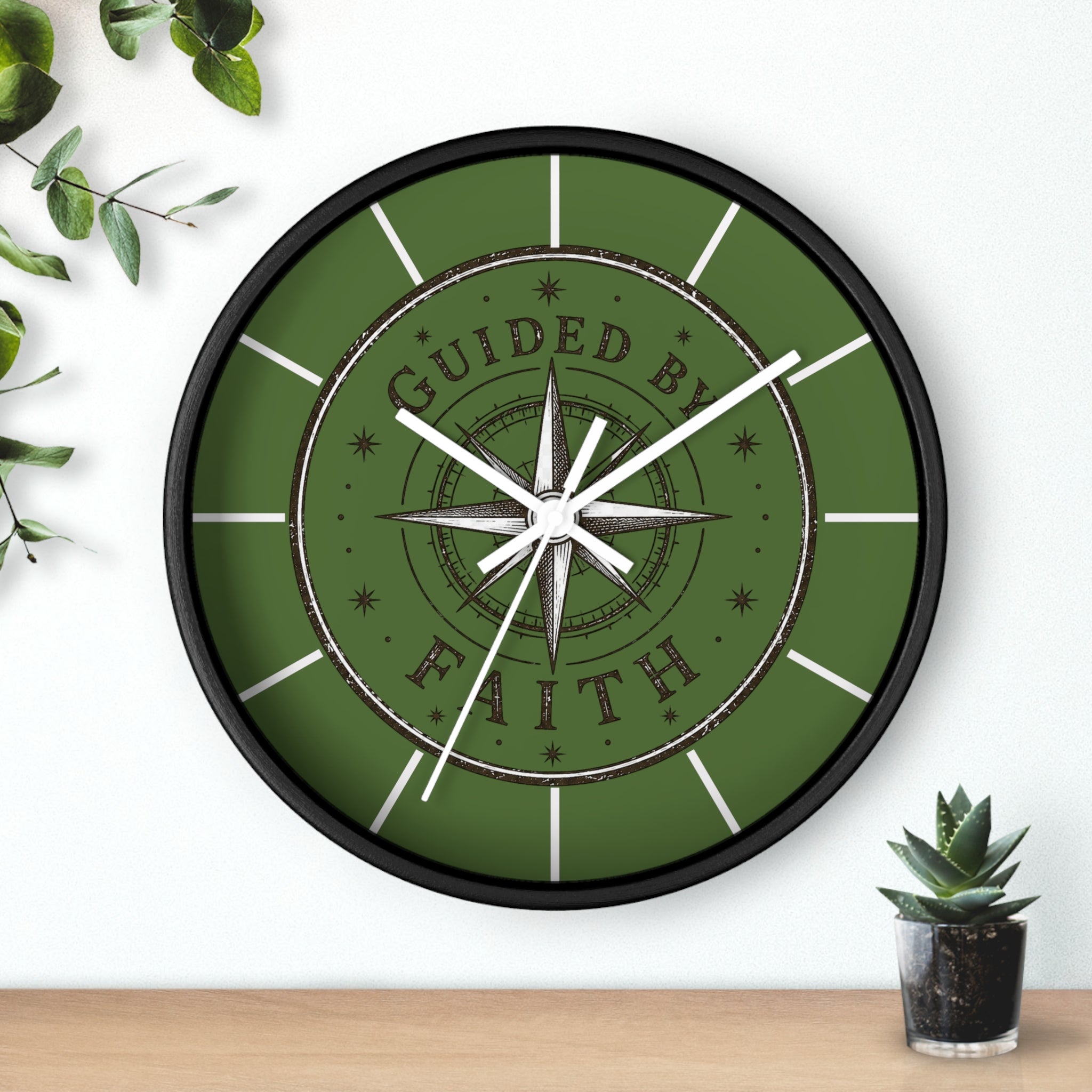 Rustic inspirational wall clock featuring a vintage compass design and the words “Guided by Faith” on an olive-green distressed background with silent movement.