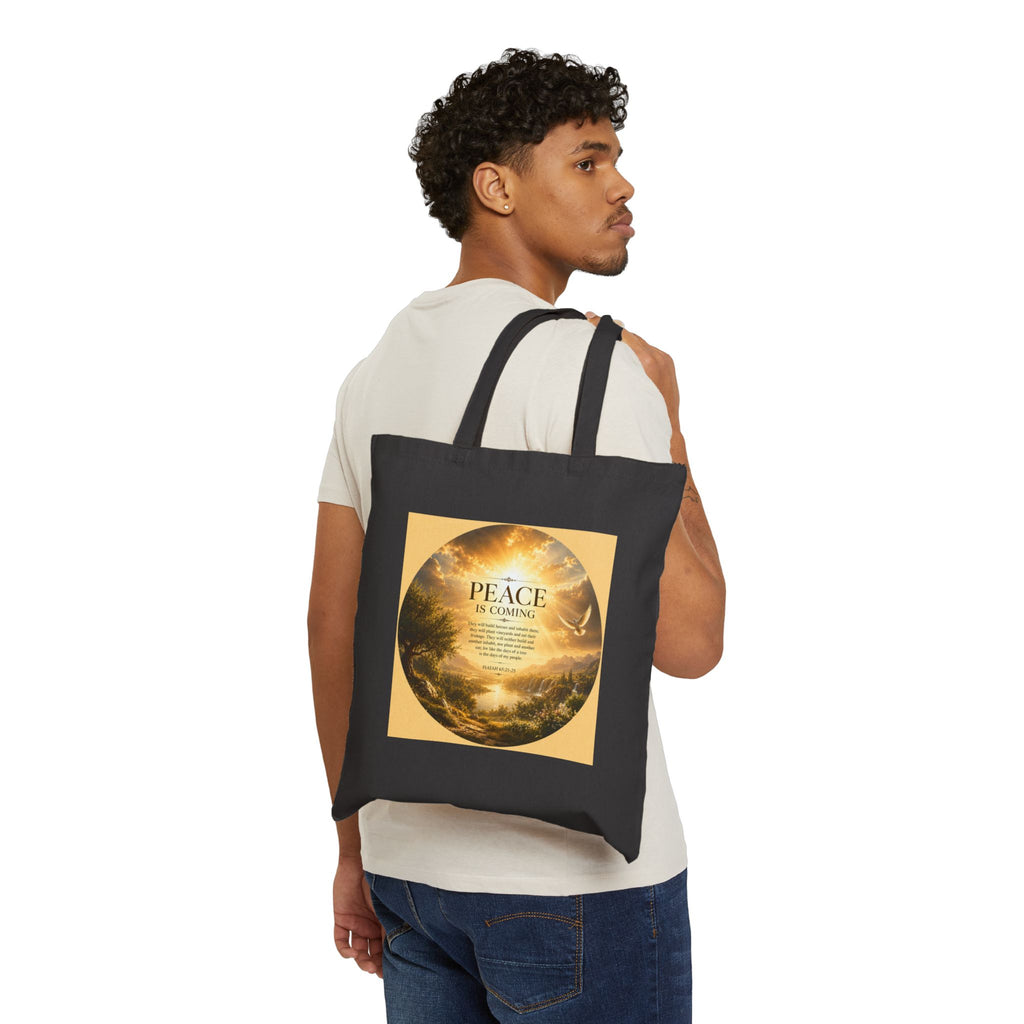 Christian cotton canvas tote bag featuring Isaiah 65:21-25 and the message “Peace Is Coming,” with golden paradise landscape artwork, waterfalls, mountains, river, white dove, and radiant sunlight.