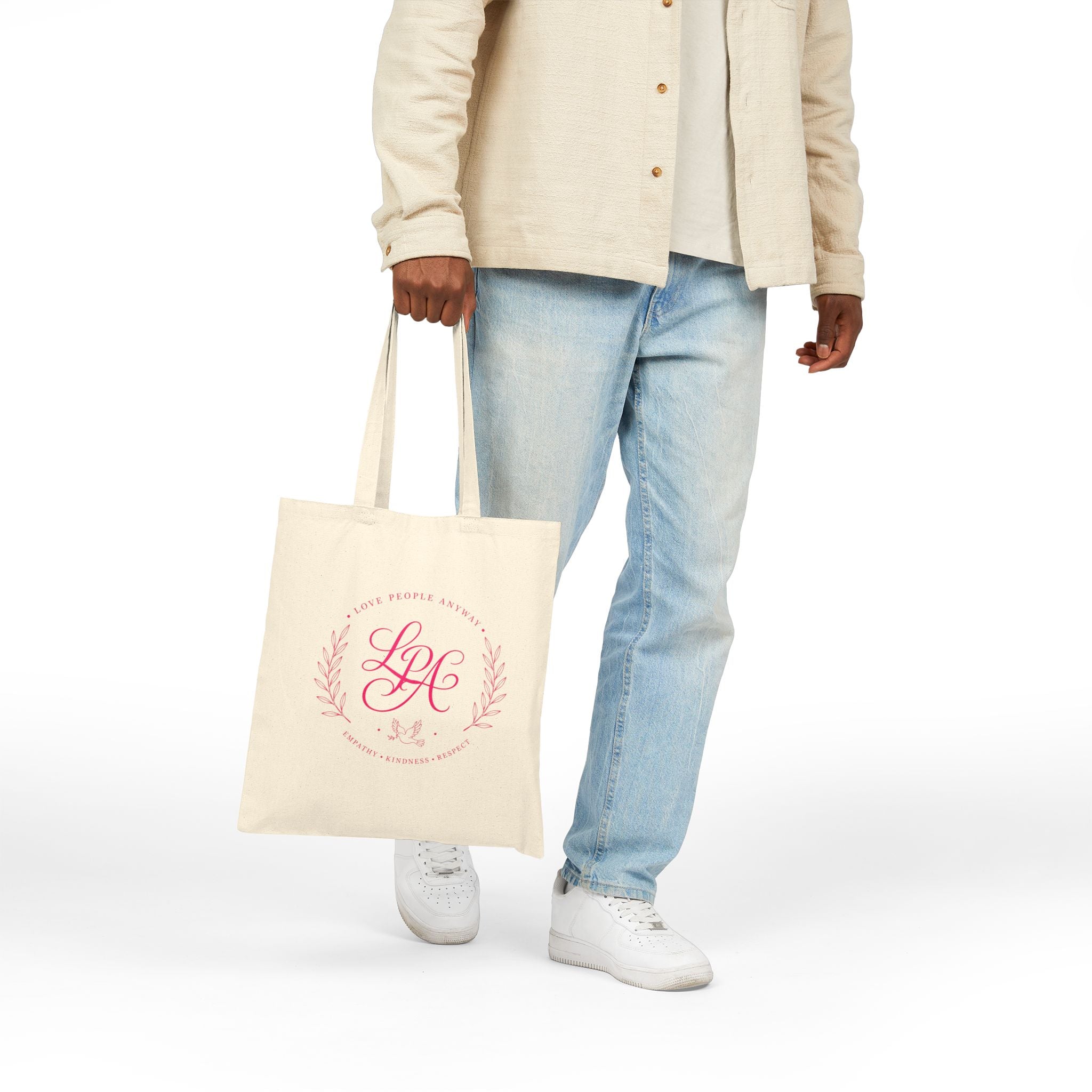 Pink monogram cotton canvas tote bag featuring the message “Love People Anyway,” laurel branches, a dove carrying an olive branch, and the words empathy, kindness, and respect in an elegant boutique design.