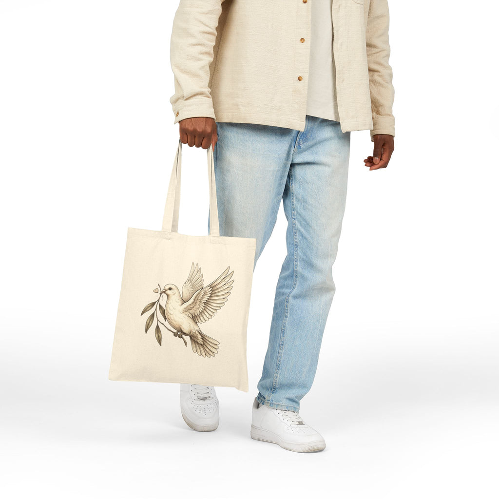 Cotton canvas tote bag featuring a vintage-style dove carrying an olive branch, symbolizing peace, hope, faith, and renewal in a rustic black-and-cream design.
