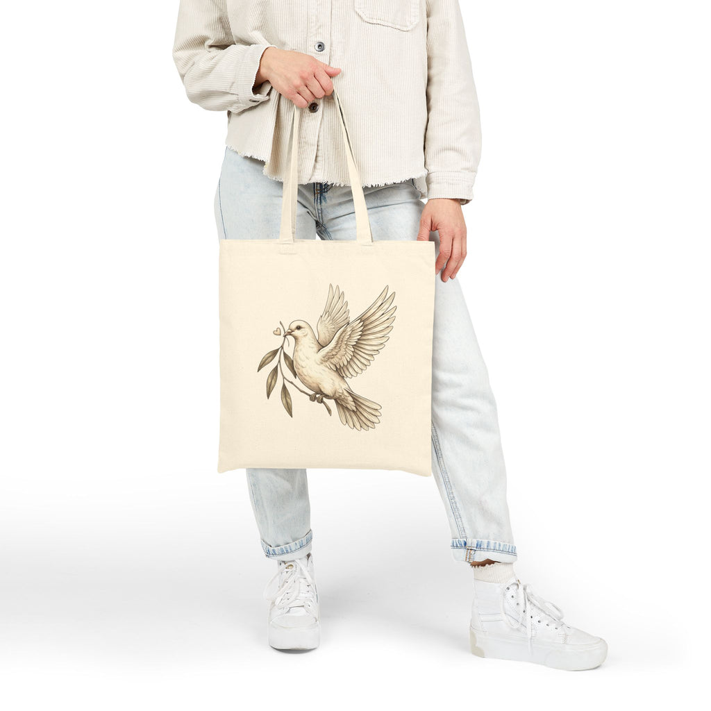 Cotton canvas tote bag featuring a vintage-style dove carrying an olive branch, symbolizing peace, hope, faith, and renewal in a rustic black-and-cream design.