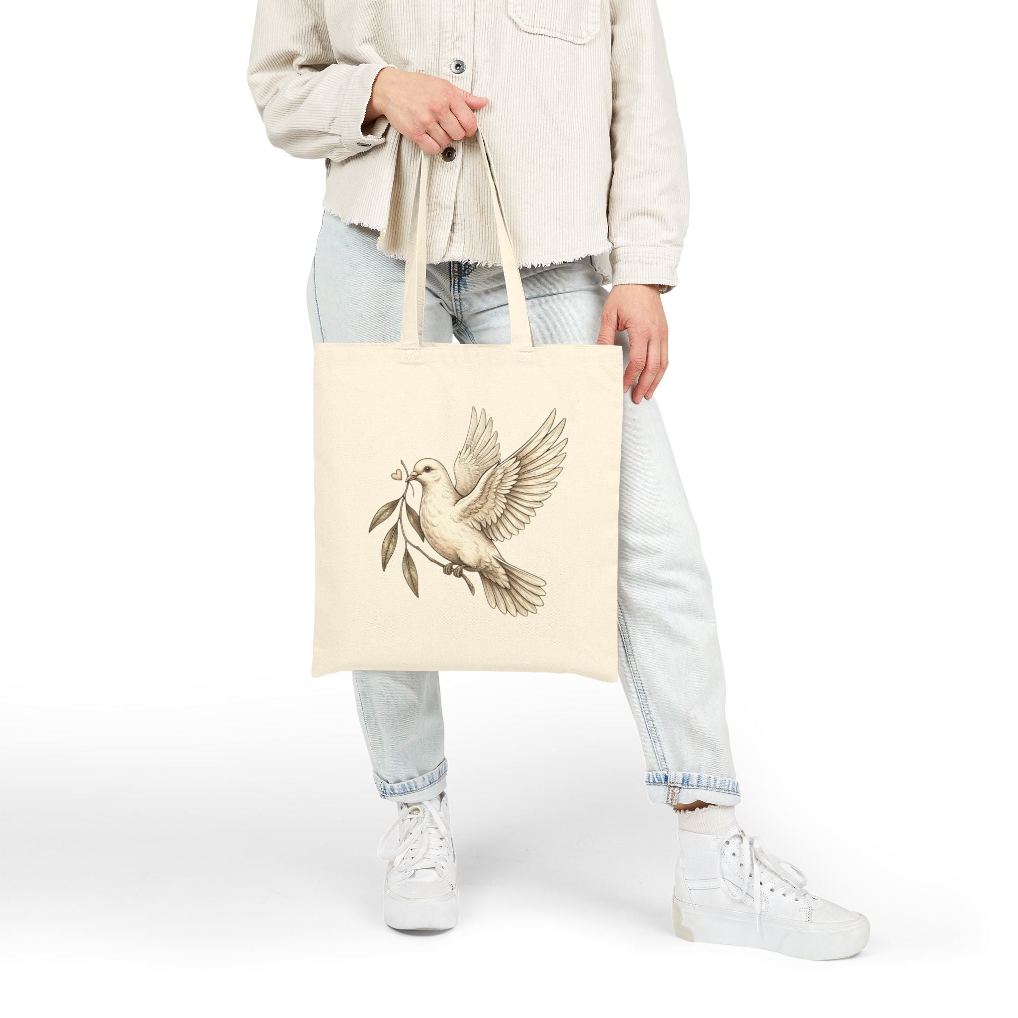 Cotton canvas tote bag featuring a vintage-style dove carrying an olive branch, symbolizing peace, hope, faith, and renewal in a rustic black-and-cream design.