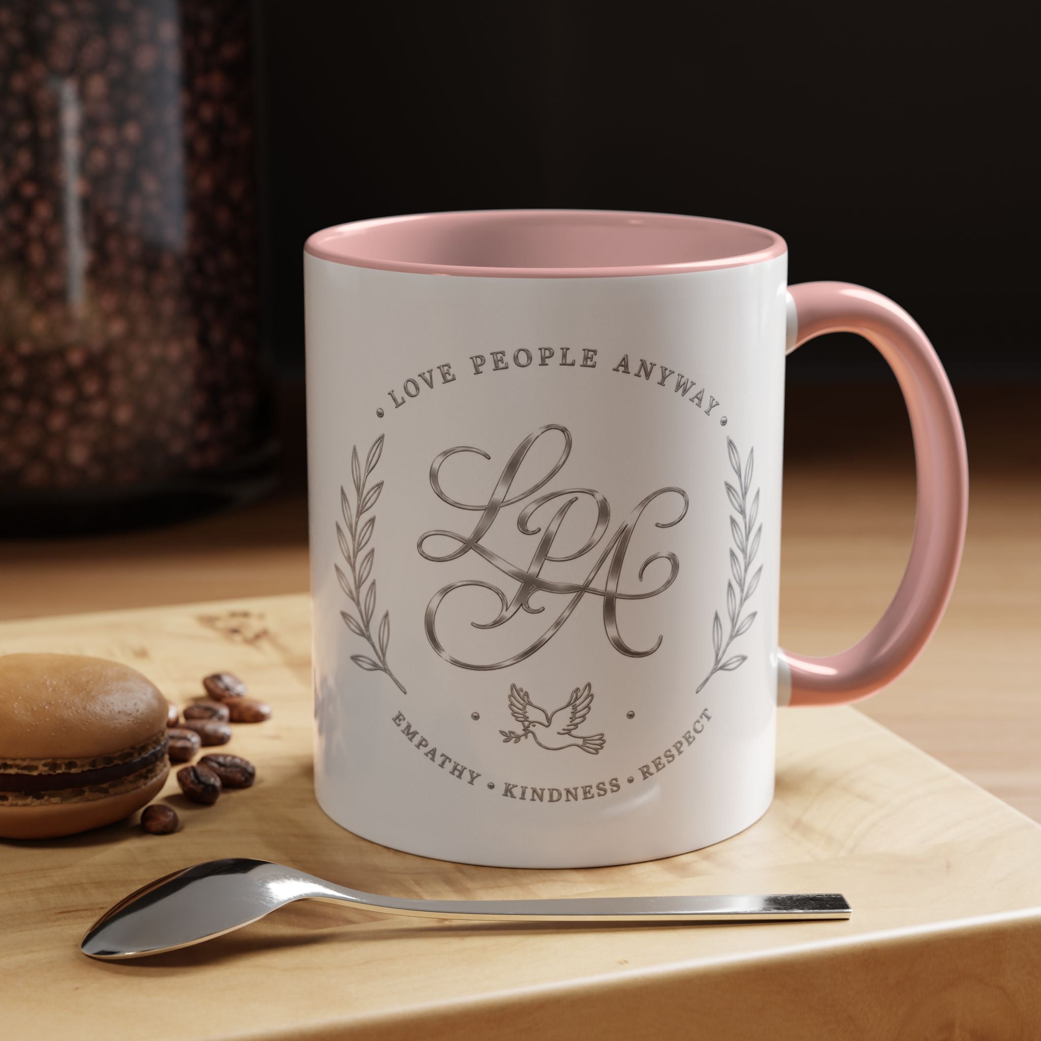 Inspirational ceramic coffee mug featuring silver “Love People Anyway” script, elegant monogram styling, decorative wreath accents, and contrasting handle and interior.