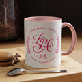 Inspirational ceramic coffee mug featuring soft pink “Love People Anyway” lettering, laurel accents, a dove motif, and contrasting black handle and interior.