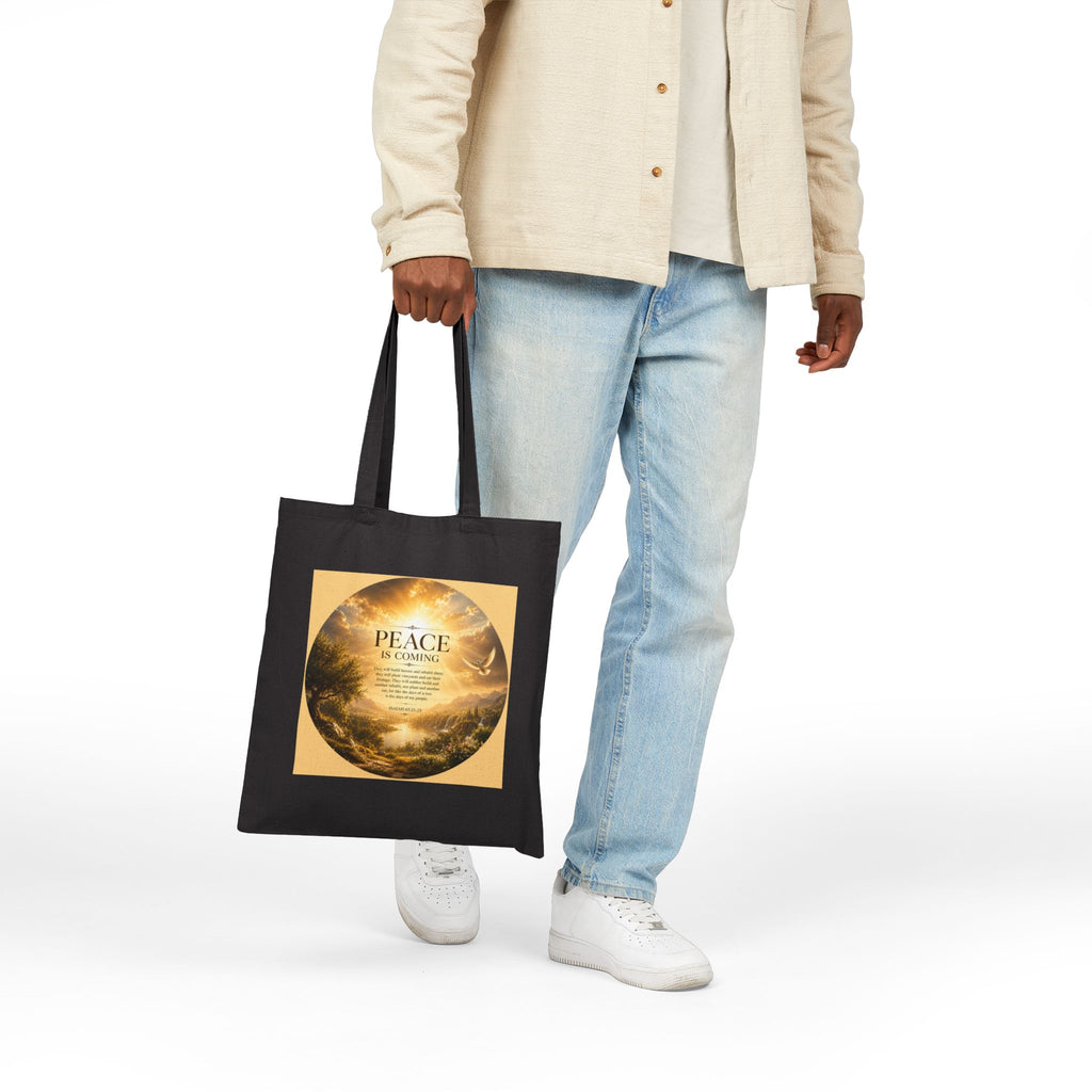 Christian cotton canvas tote bag featuring Isaiah 65:21-25 and the message “Peace Is Coming,” with golden paradise landscape artwork, waterfalls, mountains, river, white dove, and radiant sunlight.