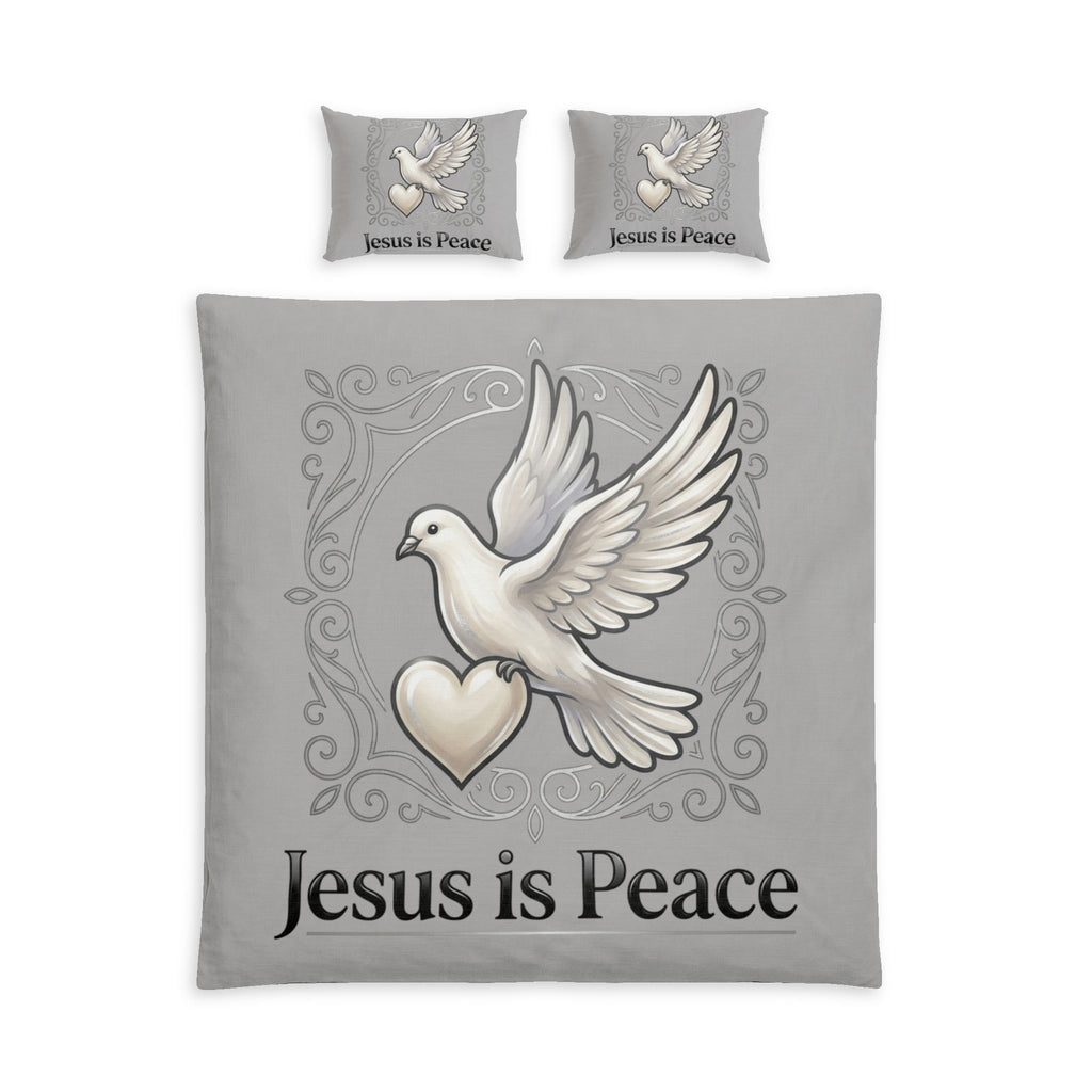 A bedding set featuring a duvet cover and two matching pillowcases in light gray, each printed with a white dove holding a heart and the words 'Jesus is Peace' in black script.