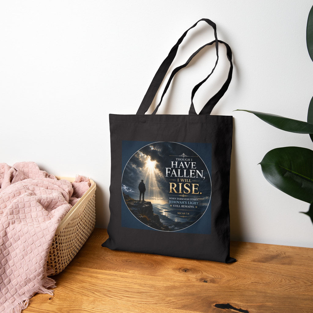 Christian cotton canvas tote bag featuring Micah 7:8 and the message “Though I Have Fallen, I Will Rise,” with dramatic mountain landscape artwork, storm clouds, rays of light, and inspirational faith-based design.
