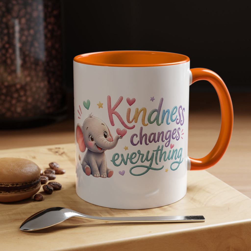 Cute ceramic coffee mug featuring a pastel baby elephant and the uplifting message “Kindness Changes Everything” with colorful accent handle and interior.