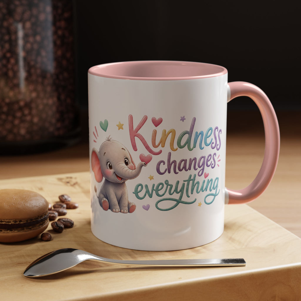 Cute ceramic coffee mug featuring a pastel baby elephant and the uplifting message “Kindness Changes Everything” with colorful accent handle and interior.