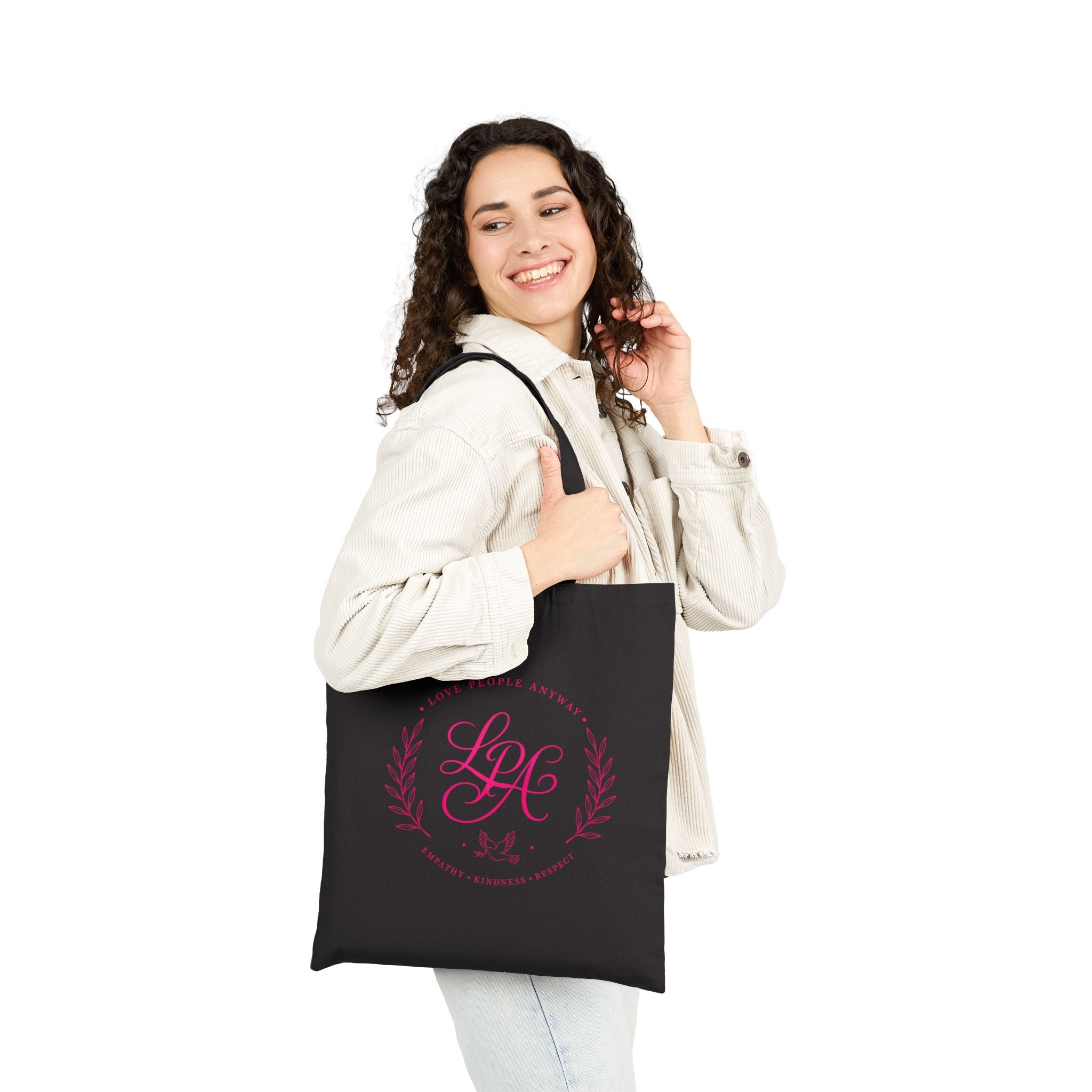 Pink monogram cotton canvas tote bag featuring the message “Love People Anyway,” laurel branches, a dove carrying an olive branch, and the words empathy, kindness, and respect in an elegant boutique design.
