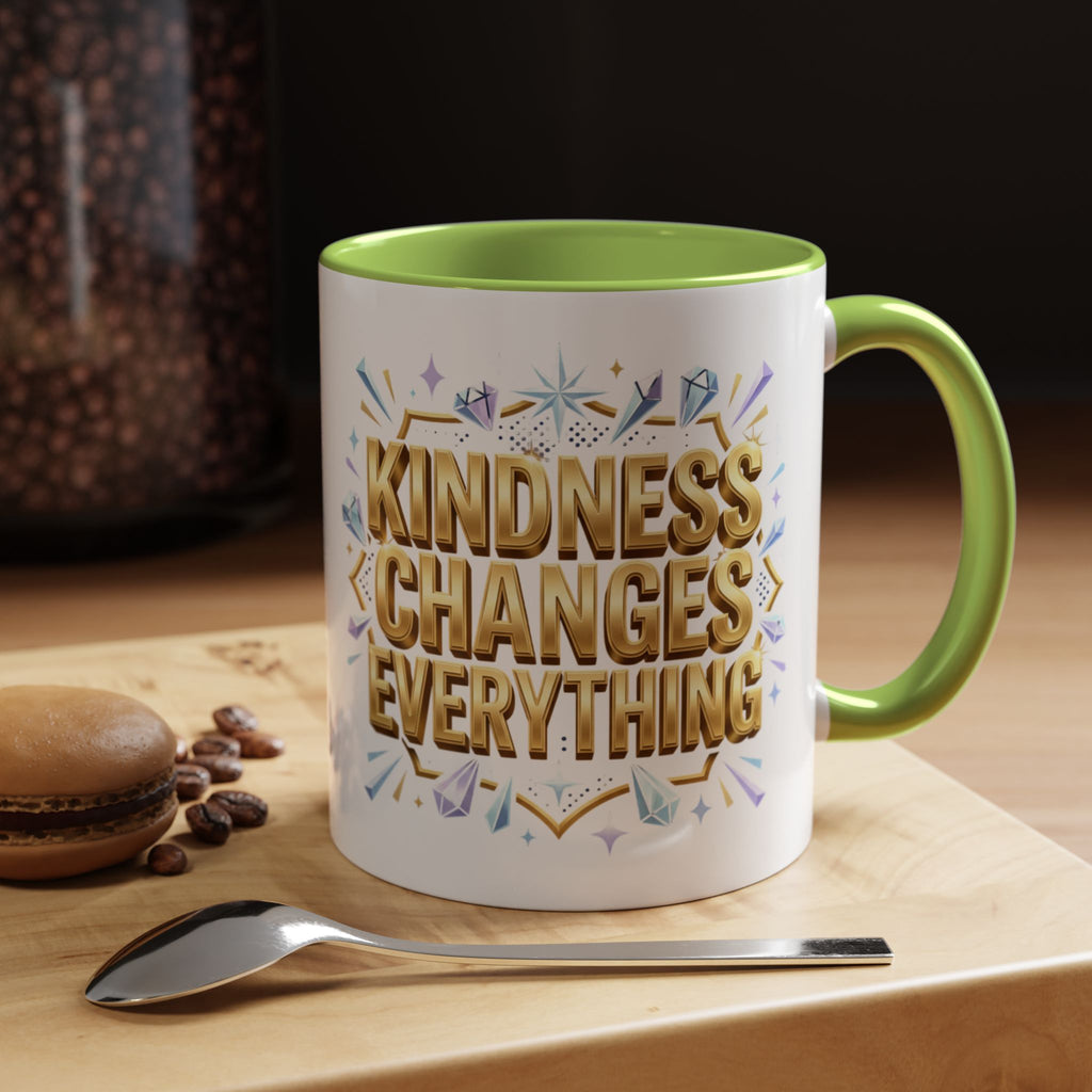 Inspirational ceramic accent coffee mug featuring “Kindness Changes Everything” in elegant gold script with sparkles and colorful accent handle and interior.
