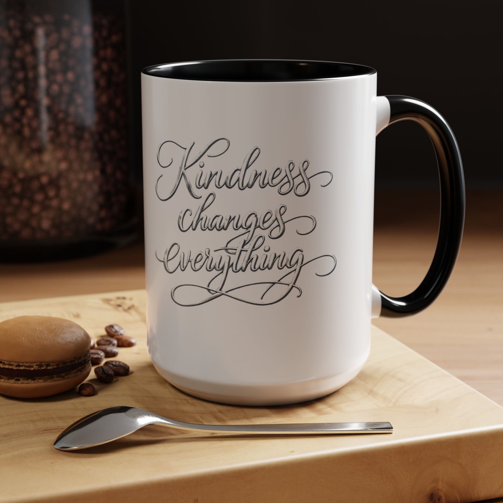 Inspirational ceramic accent coffee mug featuring elegant silver hand-lettered “Kindness Changes Everything” typography with colorful handle and interior accents.