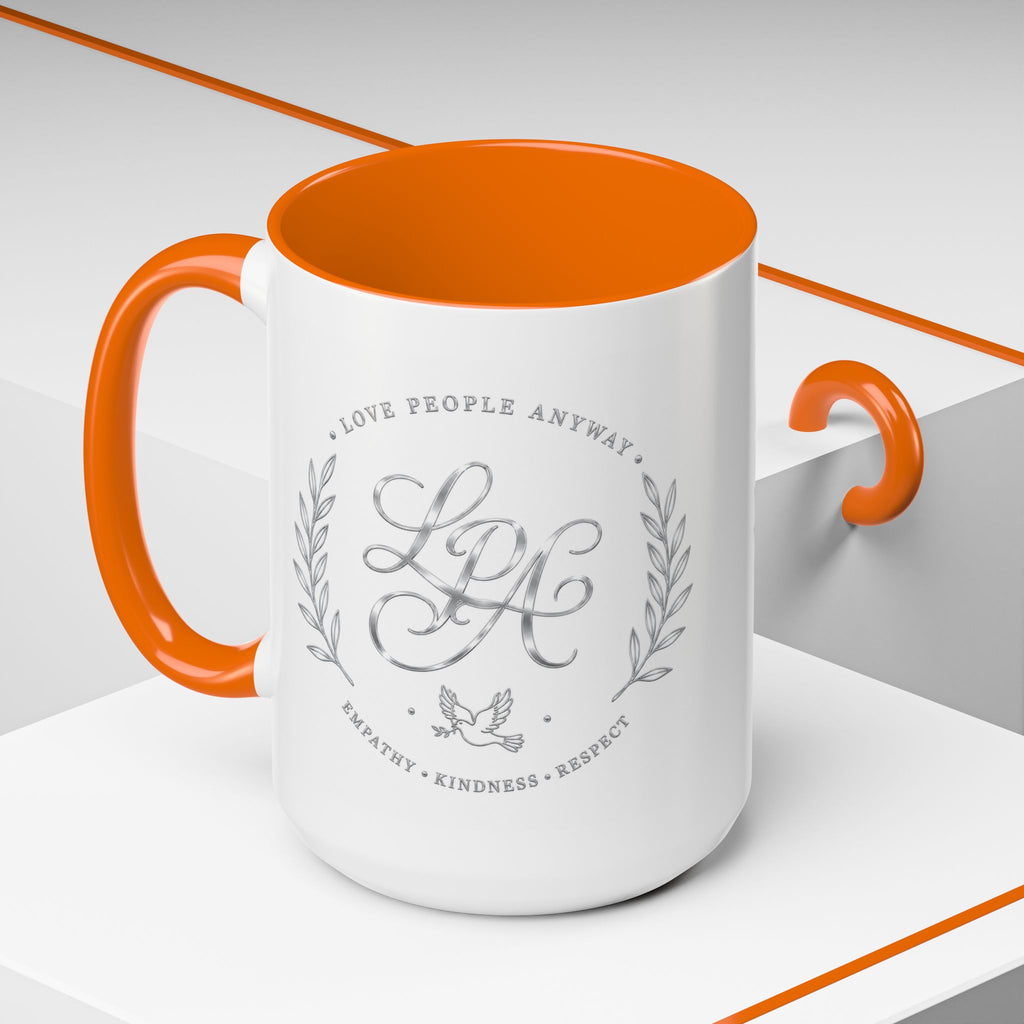 Inspirational ceramic coffee mug featuring silver “Love People Anyway” script, elegant monogram styling, decorative wreath accents, and contrasting handle and interior.