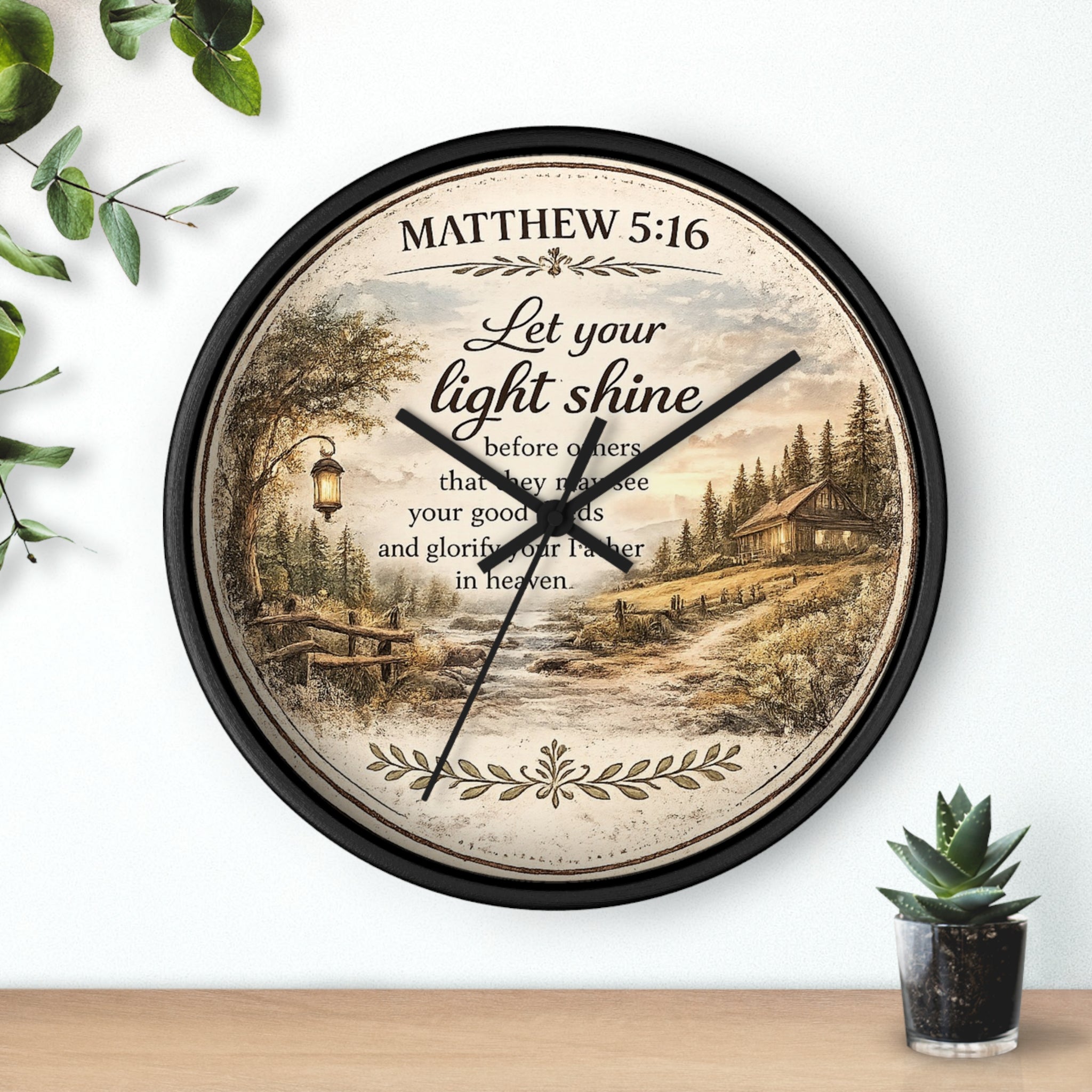 Inspirational Christian wall clock featuring Matthew 5:16 with a lantern-lit path, pine trees, rustic cottage, and warm countryside artwork in vintage farmhouse style.