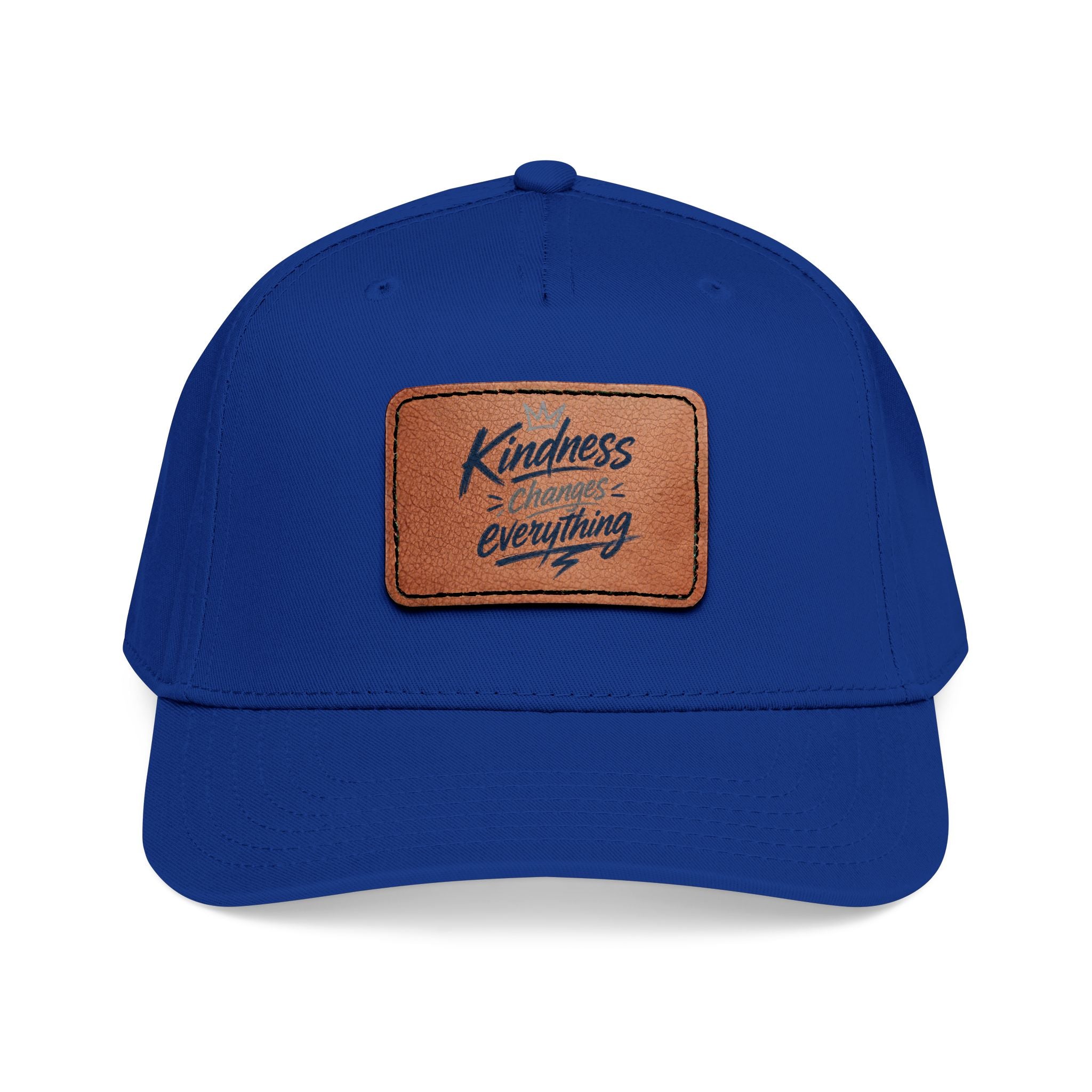 Vintage-inspired baseball cap featuring a brown leather patch with the phrase “Kindness Changes Everything” on a structured mid-profile snapback hat.