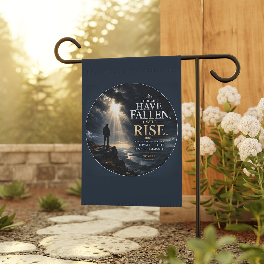 Inspirational Christian garden flag featuring golden light breaking through storm clouds over a rocky shoreline with the phrase “Though I Have Fallen, I Will Rise.”