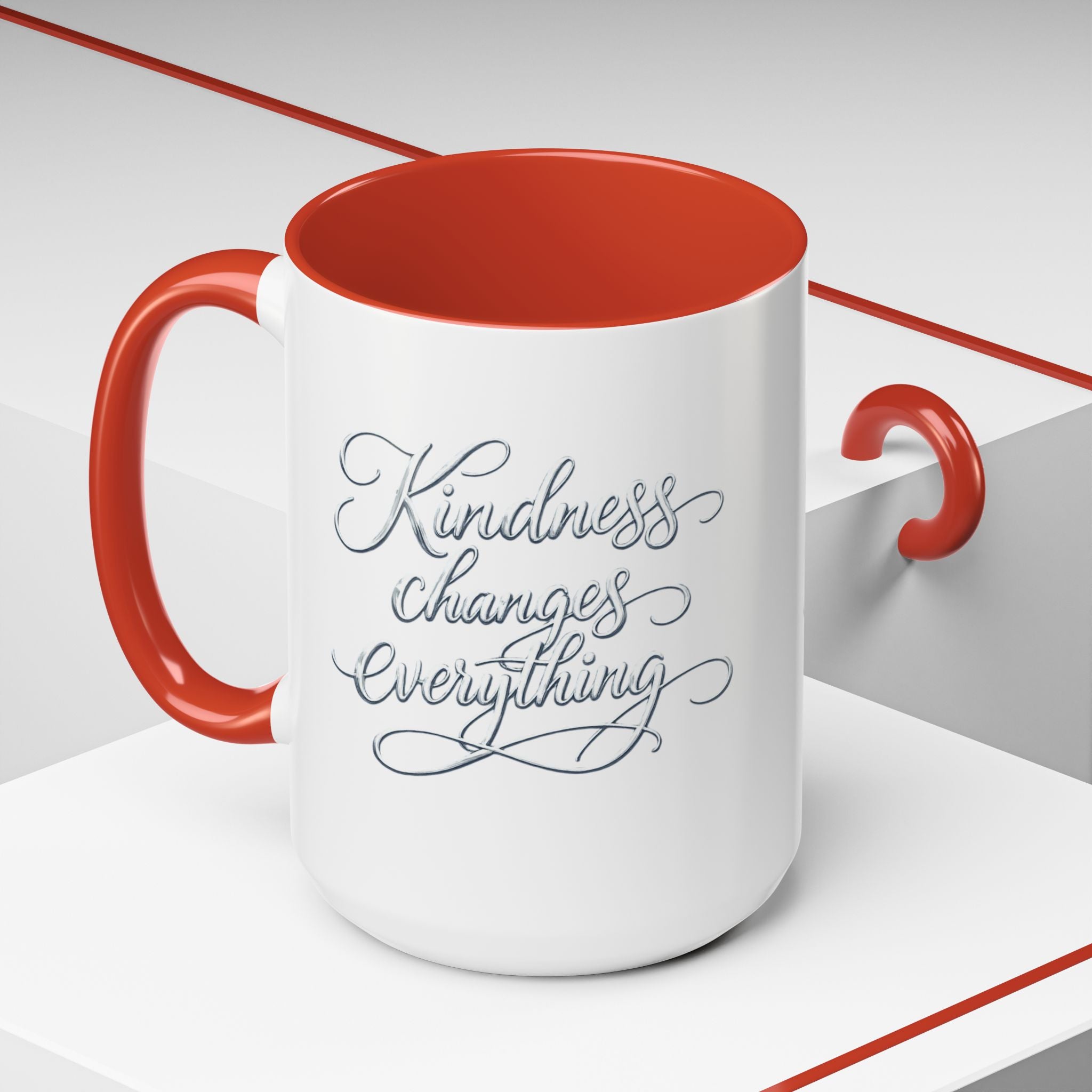 Inspirational ceramic accent coffee mug featuring elegant silver hand-lettered “Kindness Changes Everything” typography with colorful handle and interior accents.