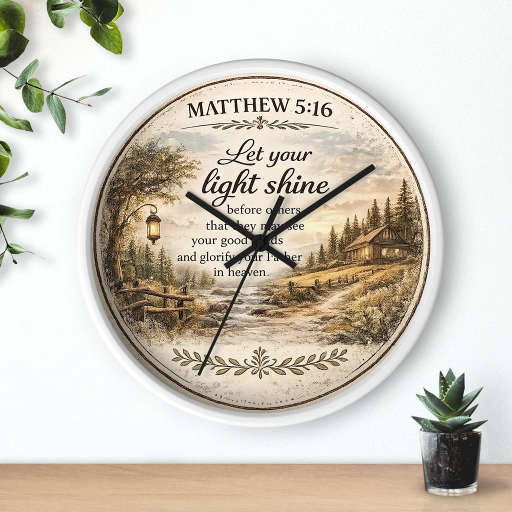 Inspirational Christian wall clock featuring Matthew 5:16 with a lantern-lit path, pine trees, rustic cottage, and warm countryside artwork in vintage farmhouse style.