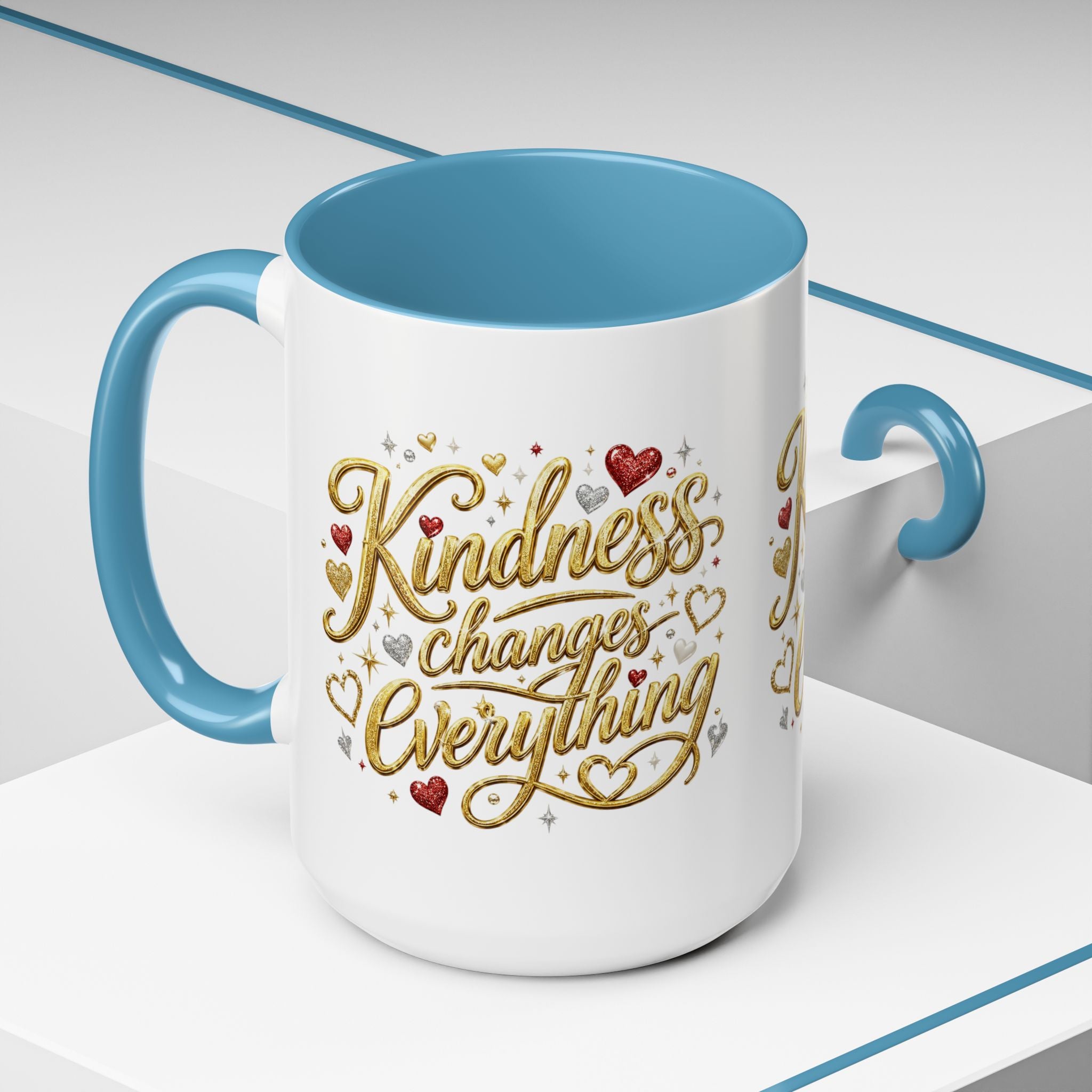 Inspirational ceramic coffee mug featuring the hand-lettered message “Kindness Changes Everything” with gold flourishes, hearts, and colorful accent handle and interior.
