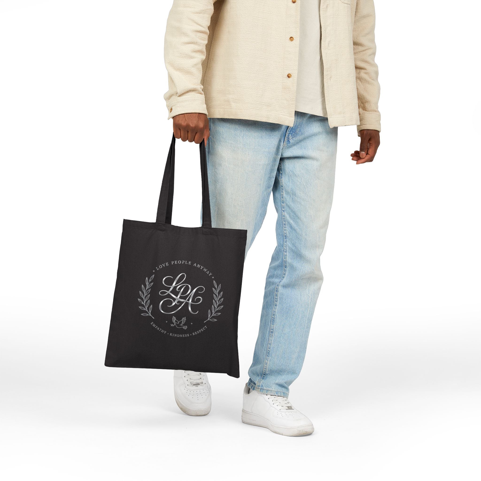 Elegant cotton canvas tote bag featuring a silver monogram crest, laurel branches, dove with olive branch, and the message “Love People Anyway” with empathy, kindness, and respect accents.