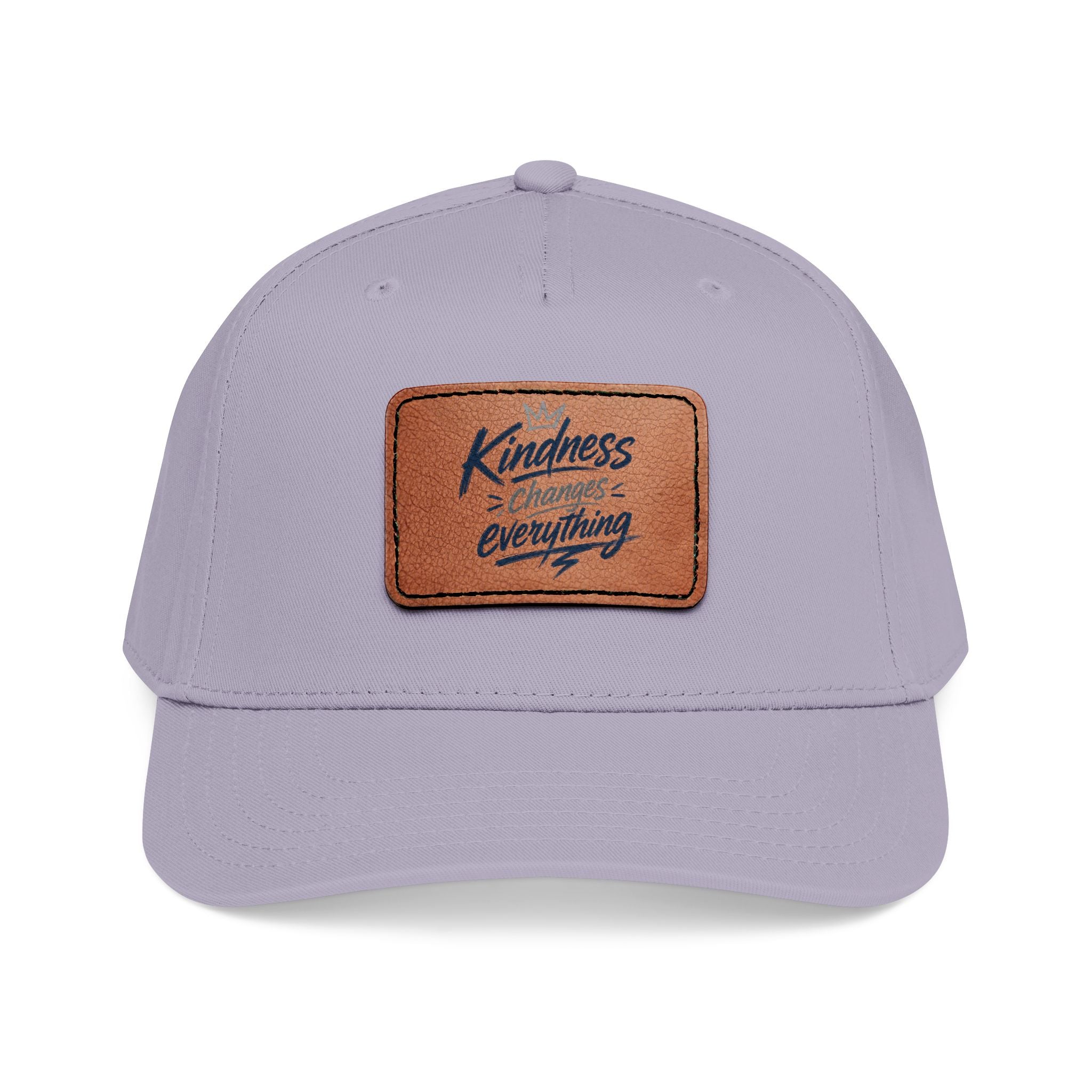 Vintage-inspired baseball cap featuring a brown leather patch with the phrase “Kindness Changes Everything” on a structured mid-profile snapback hat.