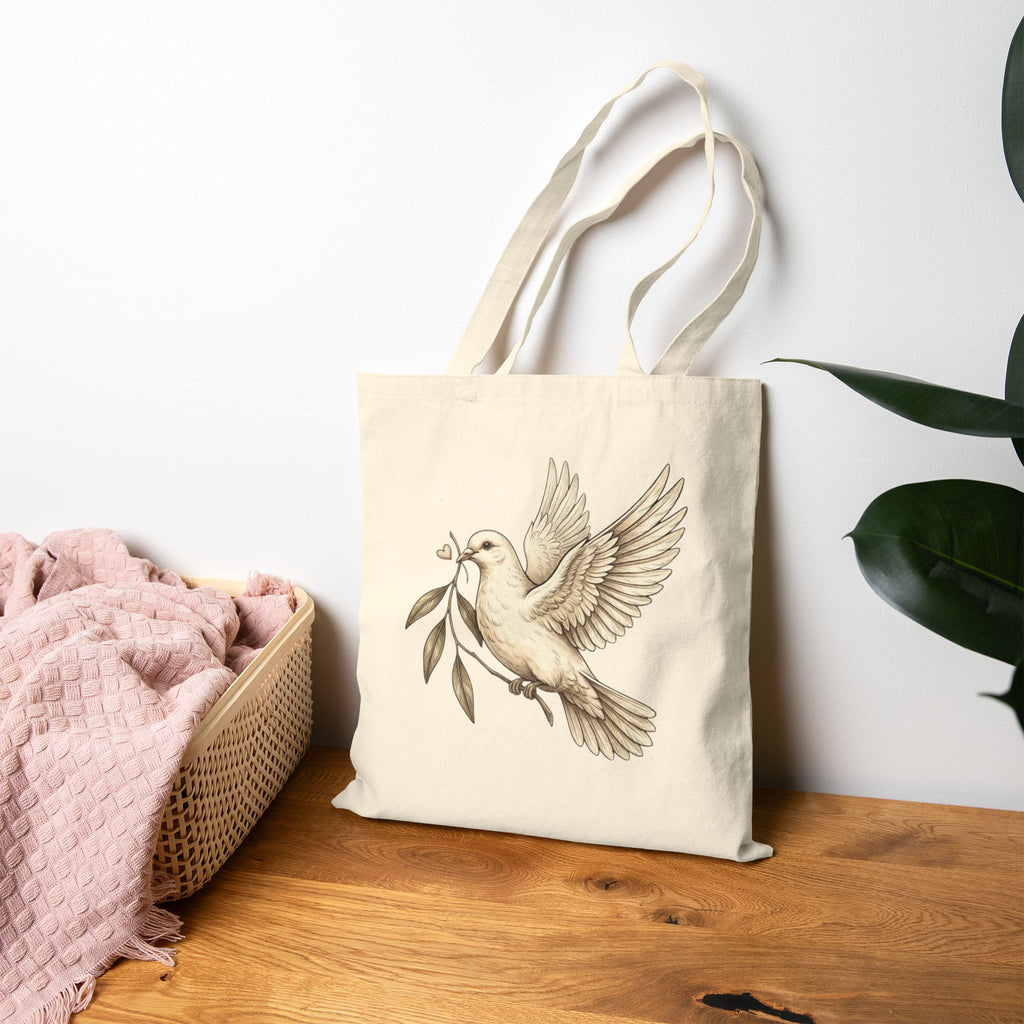Cotton canvas tote bag featuring a vintage-style dove carrying an olive branch, symbolizing peace, hope, faith, and renewal in a rustic black-and-cream design.