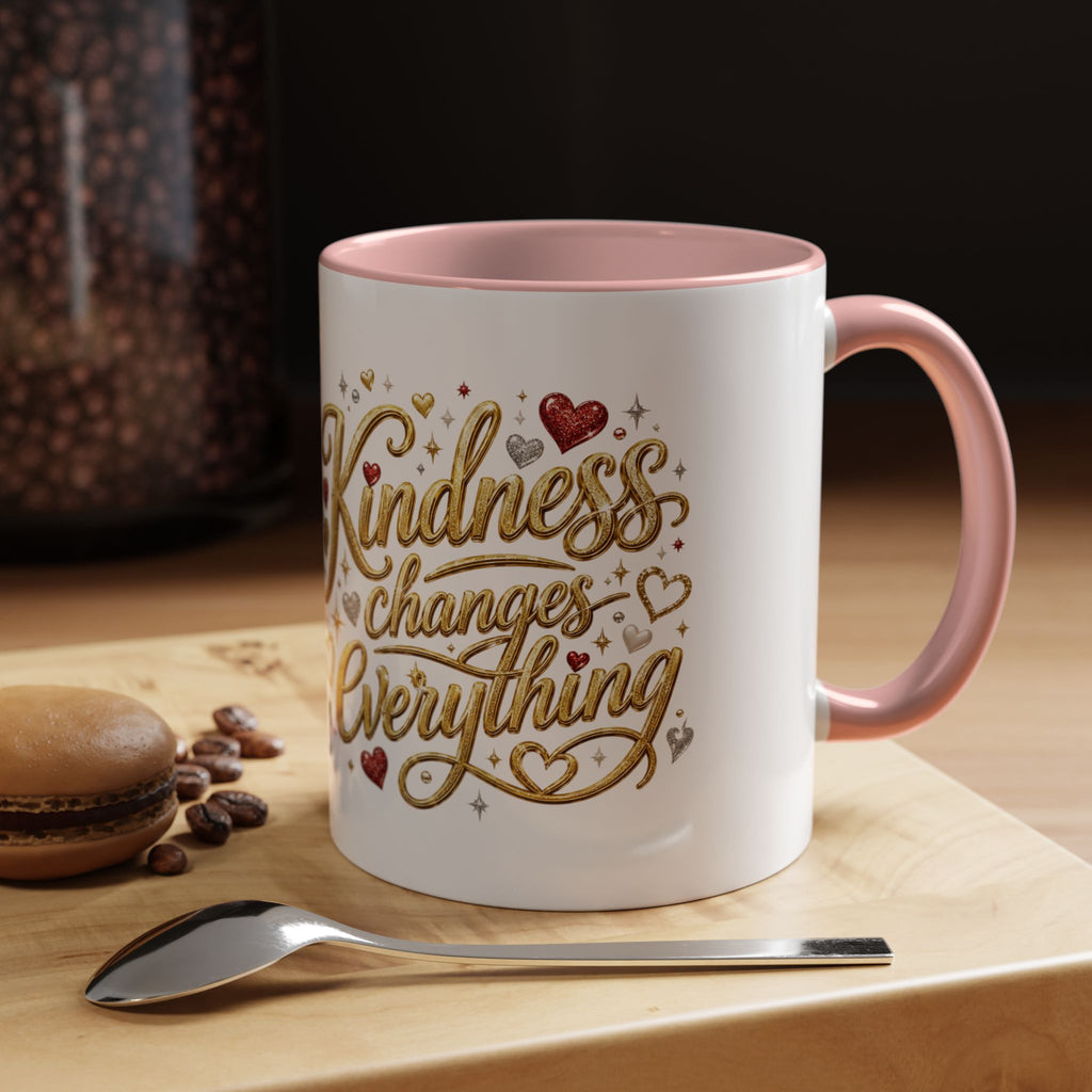 Inspirational ceramic coffee mug featuring the hand-lettered message “Kindness Changes Everything” with gold flourishes, hearts, and colorful accent handle and interior.