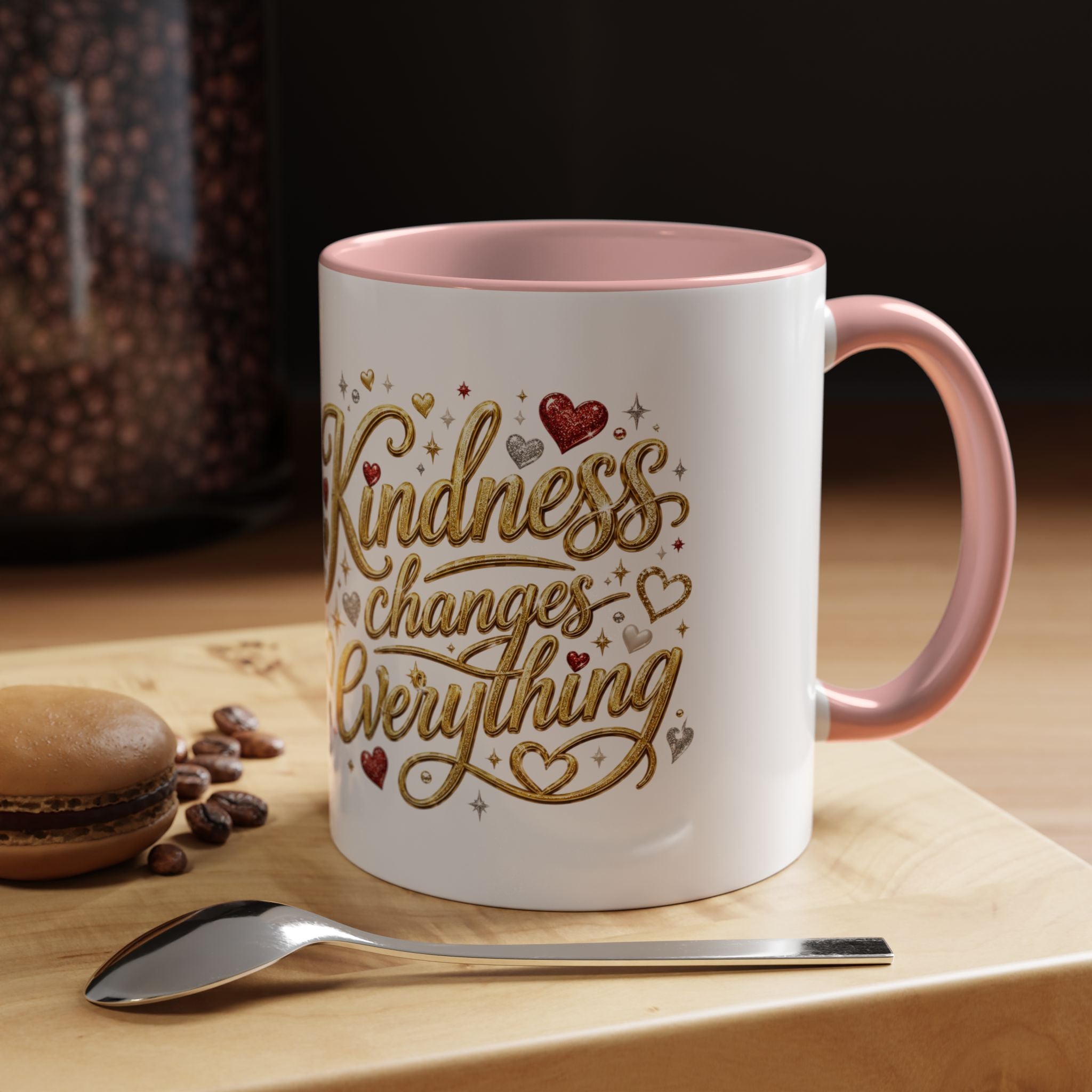 Inspirational ceramic coffee mug featuring the hand-lettered message “Kindness Changes Everything” with gold flourishes, hearts, and colorful accent handle and interior.