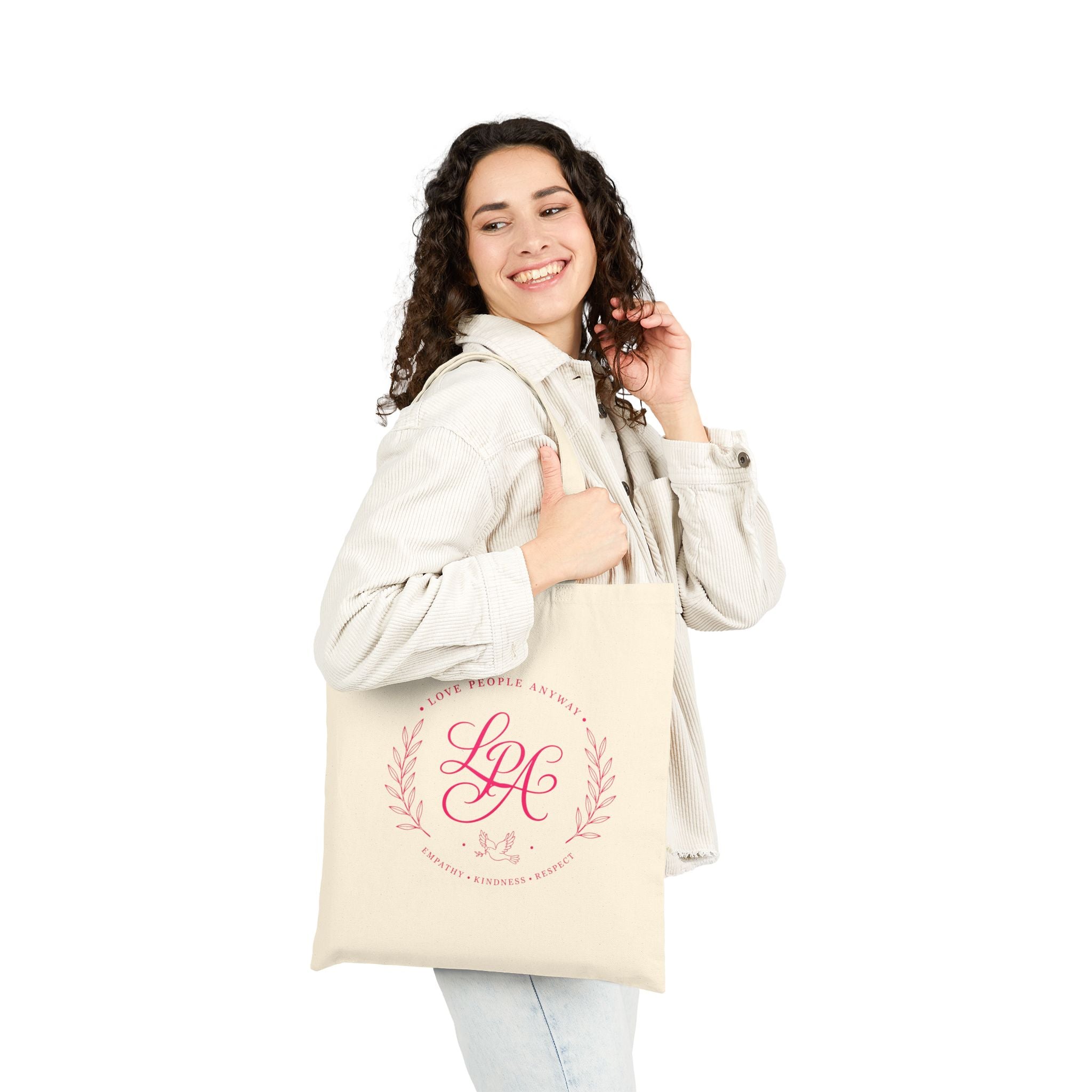 Pink monogram cotton canvas tote bag featuring the message “Love People Anyway,” laurel branches, a dove carrying an olive branch, and the words empathy, kindness, and respect in an elegant boutique design.