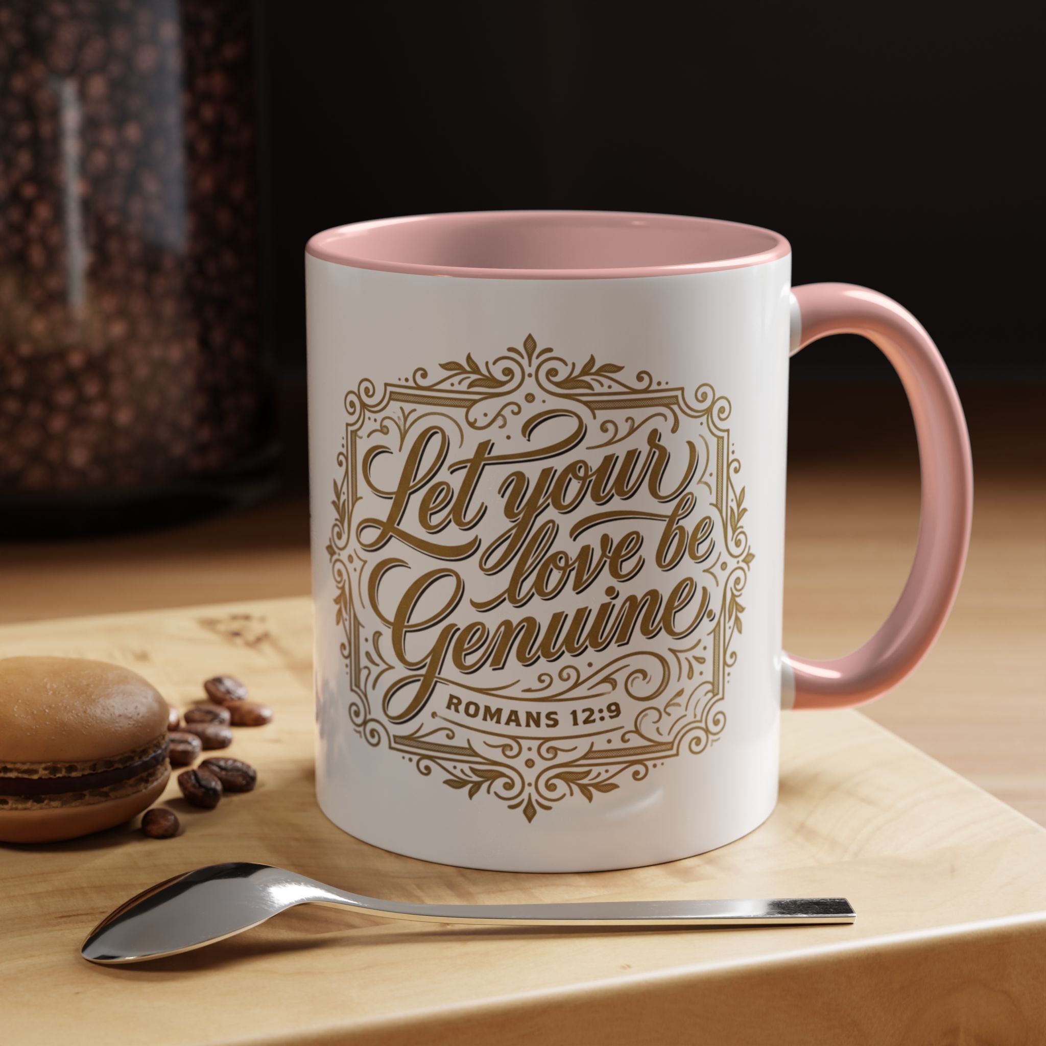 Inspirational ceramic accent coffee mug featuring Romans 12:9 and the message “Let Your Love Be Genuine” in elegant gold script with decorative flourishes and black accent handle and interior.