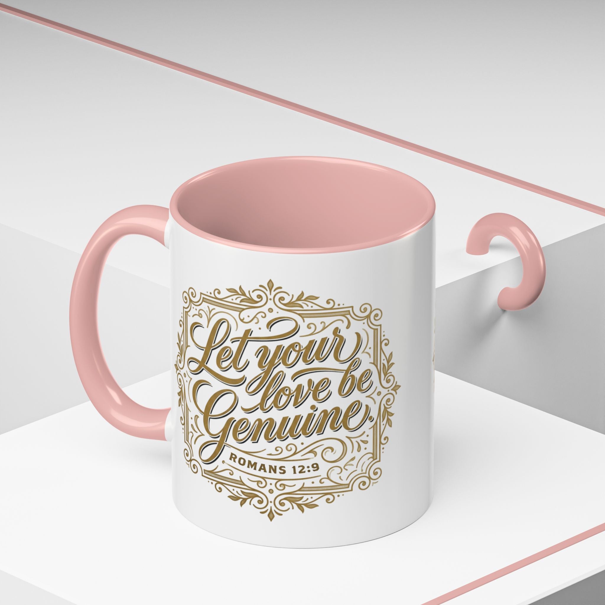 Inspirational ceramic accent coffee mug featuring Romans 12:9 and the message “Let Your Love Be Genuine” in elegant gold script with decorative flourishes and black accent handle and interior.