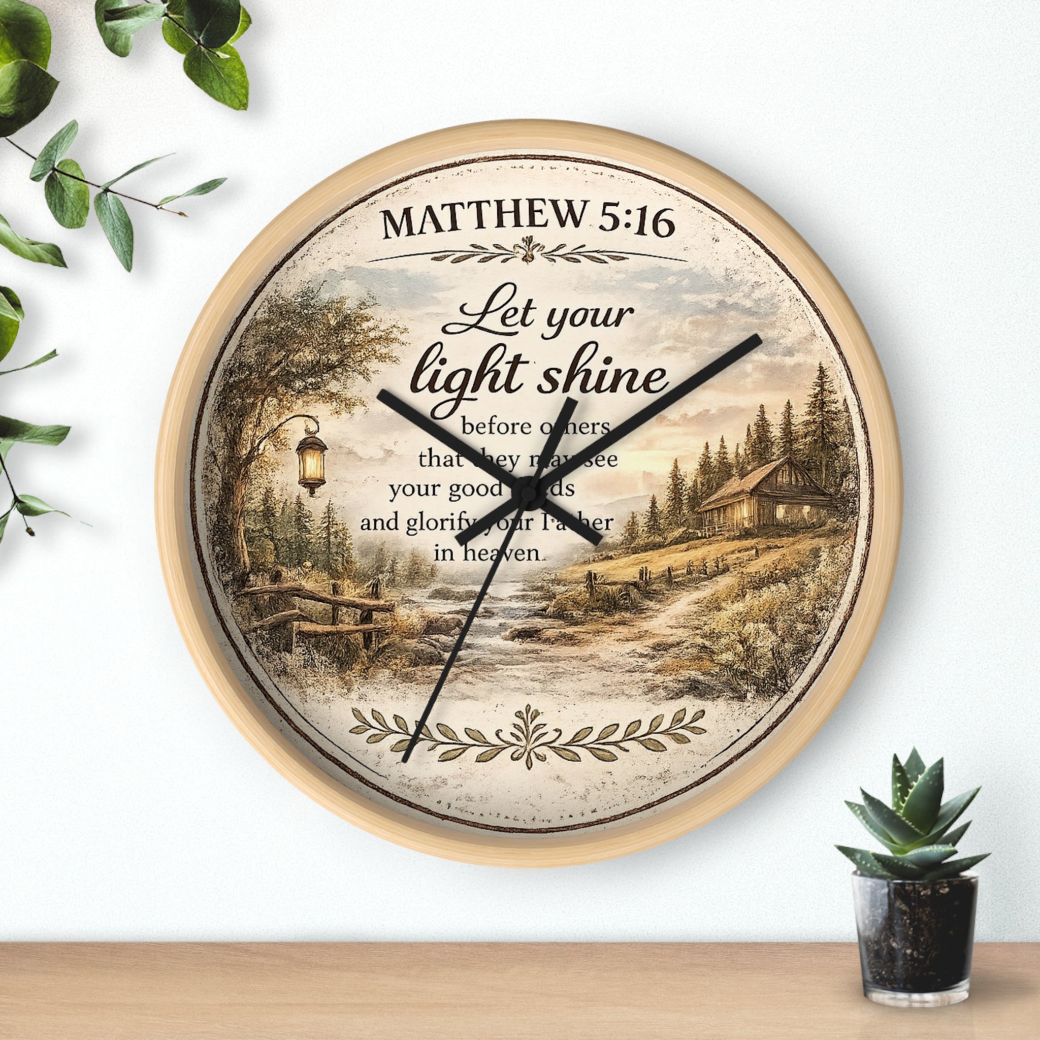 Inspirational Christian wall clock featuring Matthew 5:16 with a lantern-lit path, pine trees, rustic cottage, and warm countryside artwork in vintage farmhouse style.