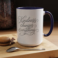 Inspirational ceramic accent coffee mug featuring elegant silver hand-lettered “Kindness Changes Everything” typography with colorful handle and interior accents.