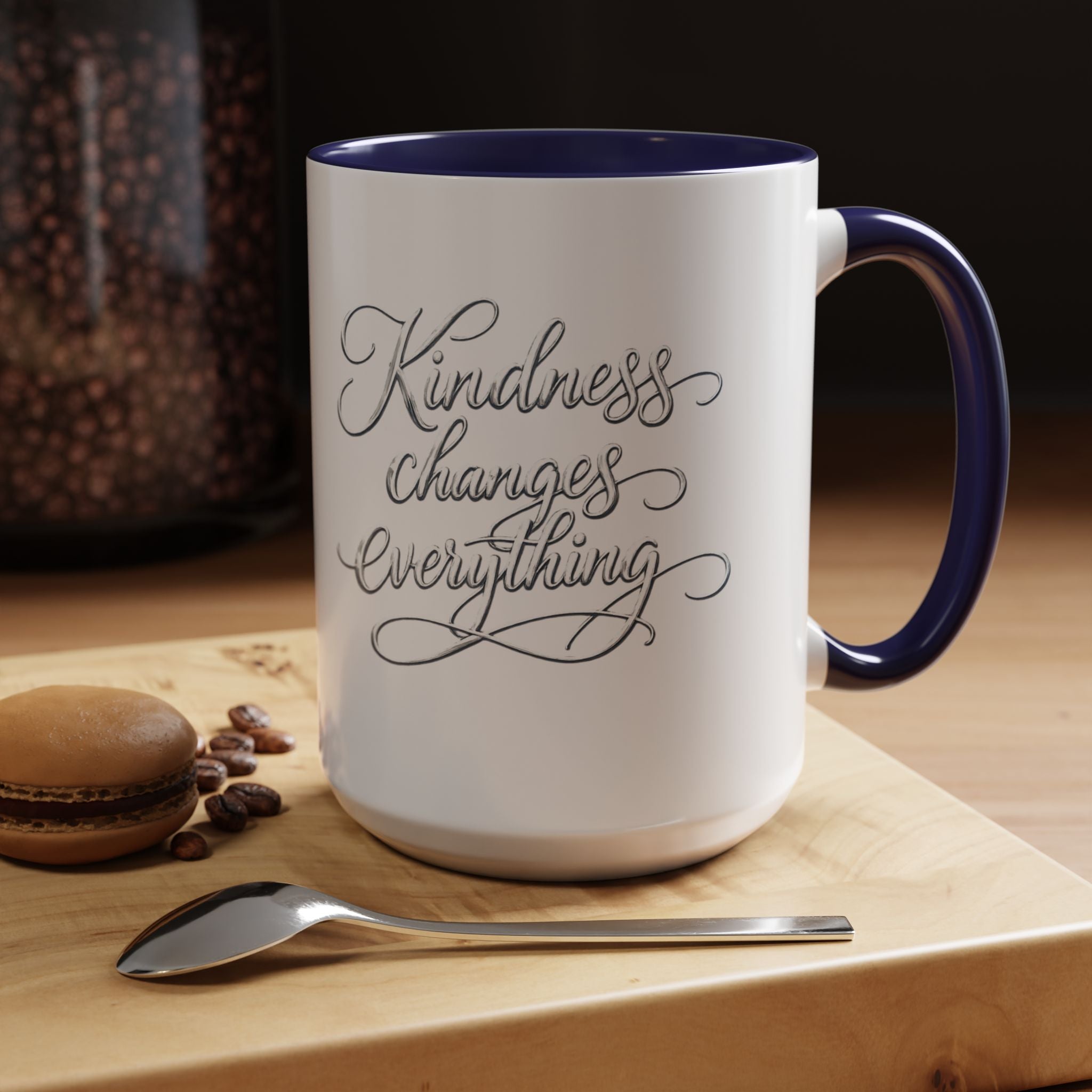 Inspirational ceramic accent coffee mug featuring elegant silver hand-lettered “Kindness Changes Everything” typography with colorful handle and interior accents.