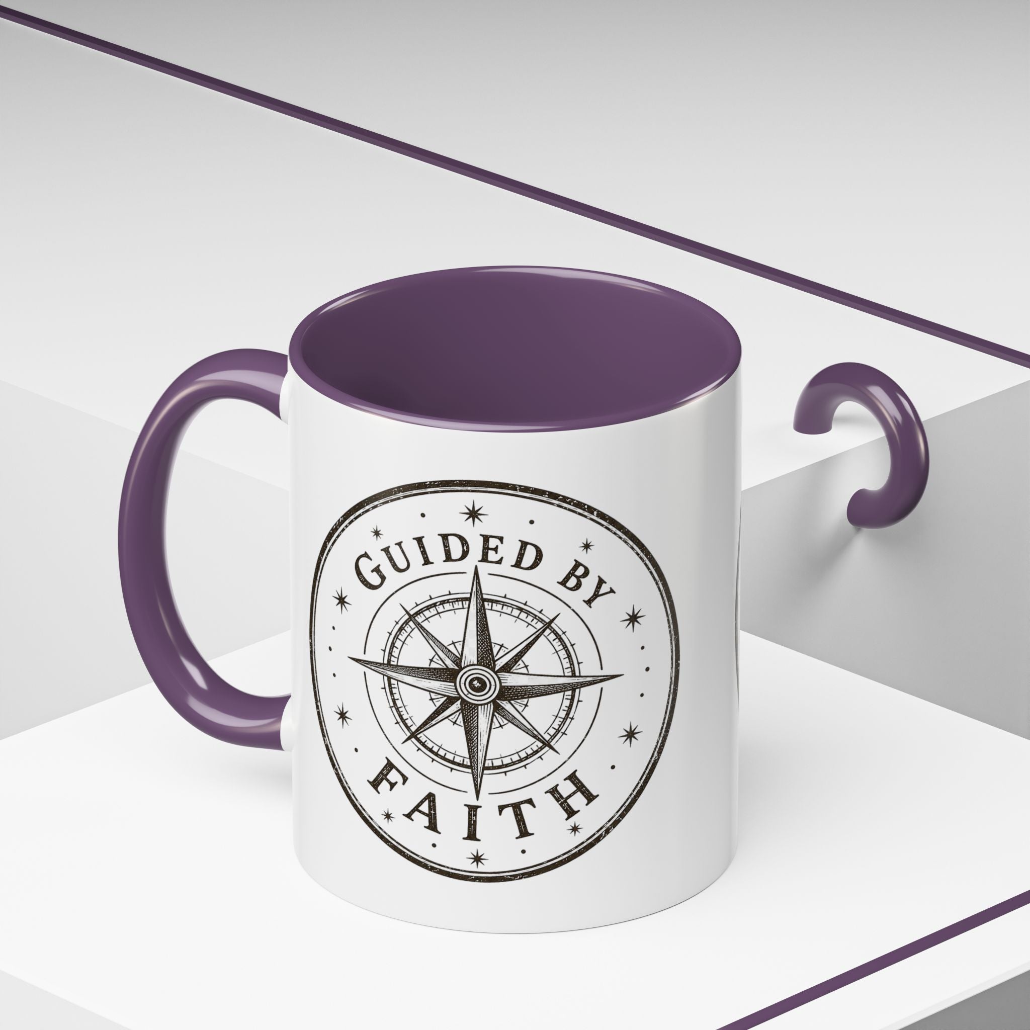 Inspirational ceramic accent coffee mug featuring a compass design and “Guided by Faith” message with colorful handle and interior accents on a glossy white mug.